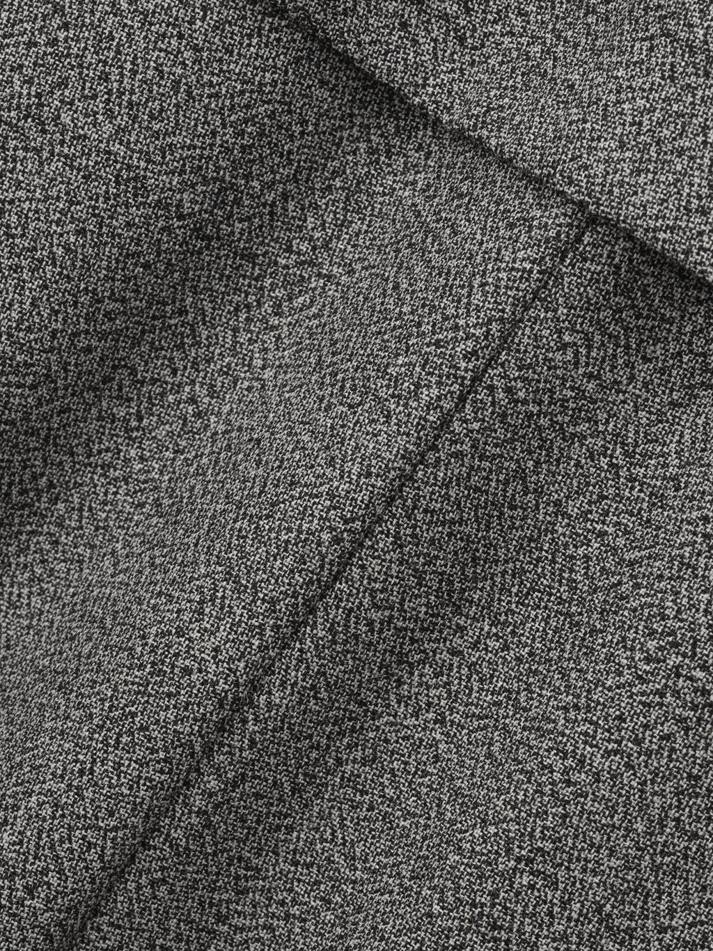 close-up of gray mouline virgin wool fabric highlighting fine textured weave and tailored seam details