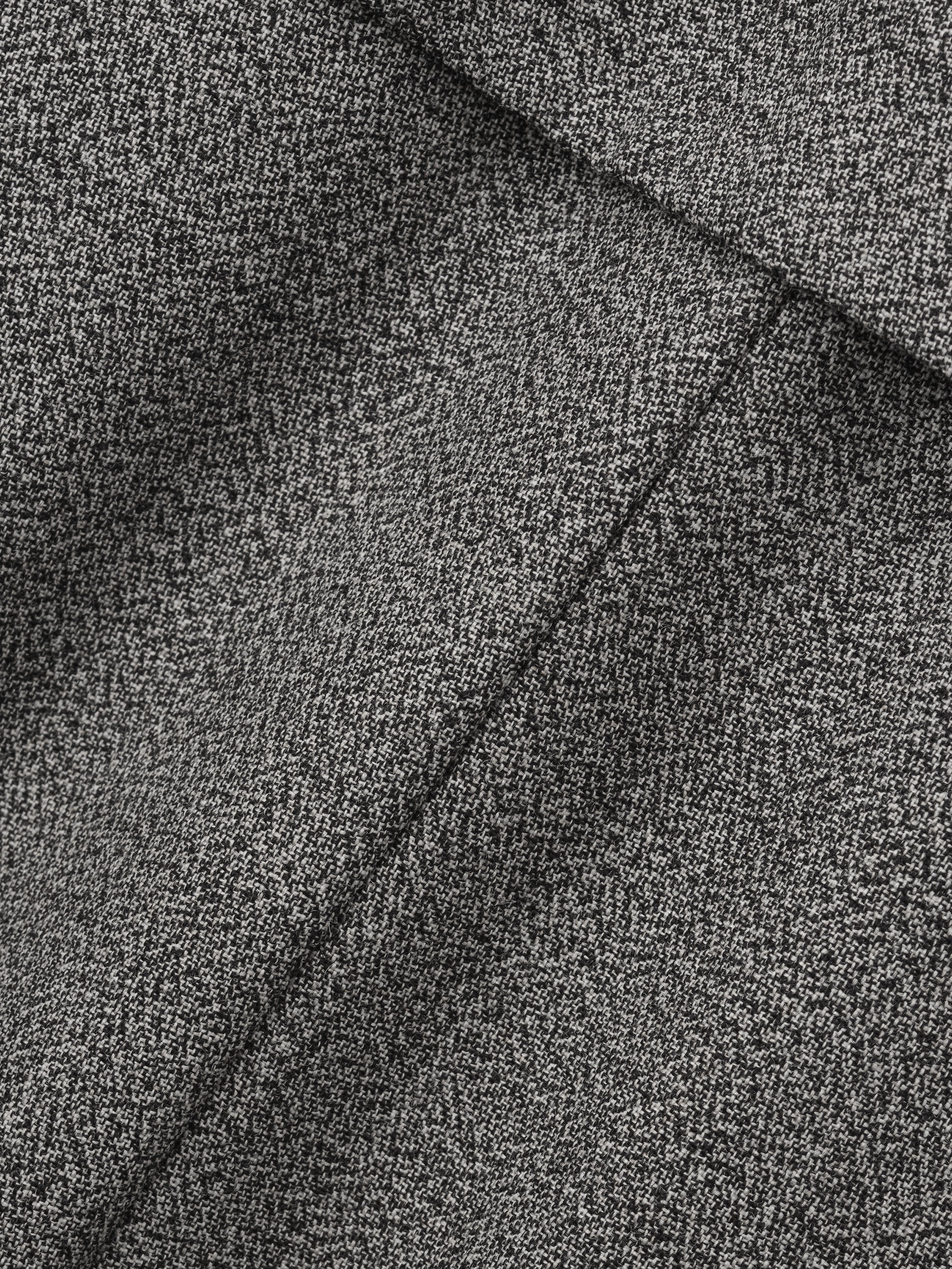 close-up of gray mouline virgin wool fabric highlighting fine textured weave and tailored seam details
