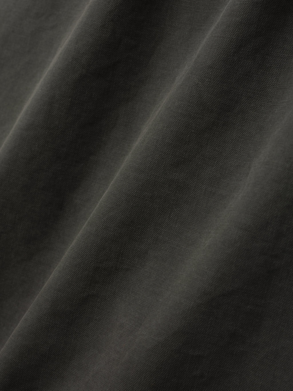 close-up of dark garment dyed heavy double weave cotton fabric with soft texture and subtle folds