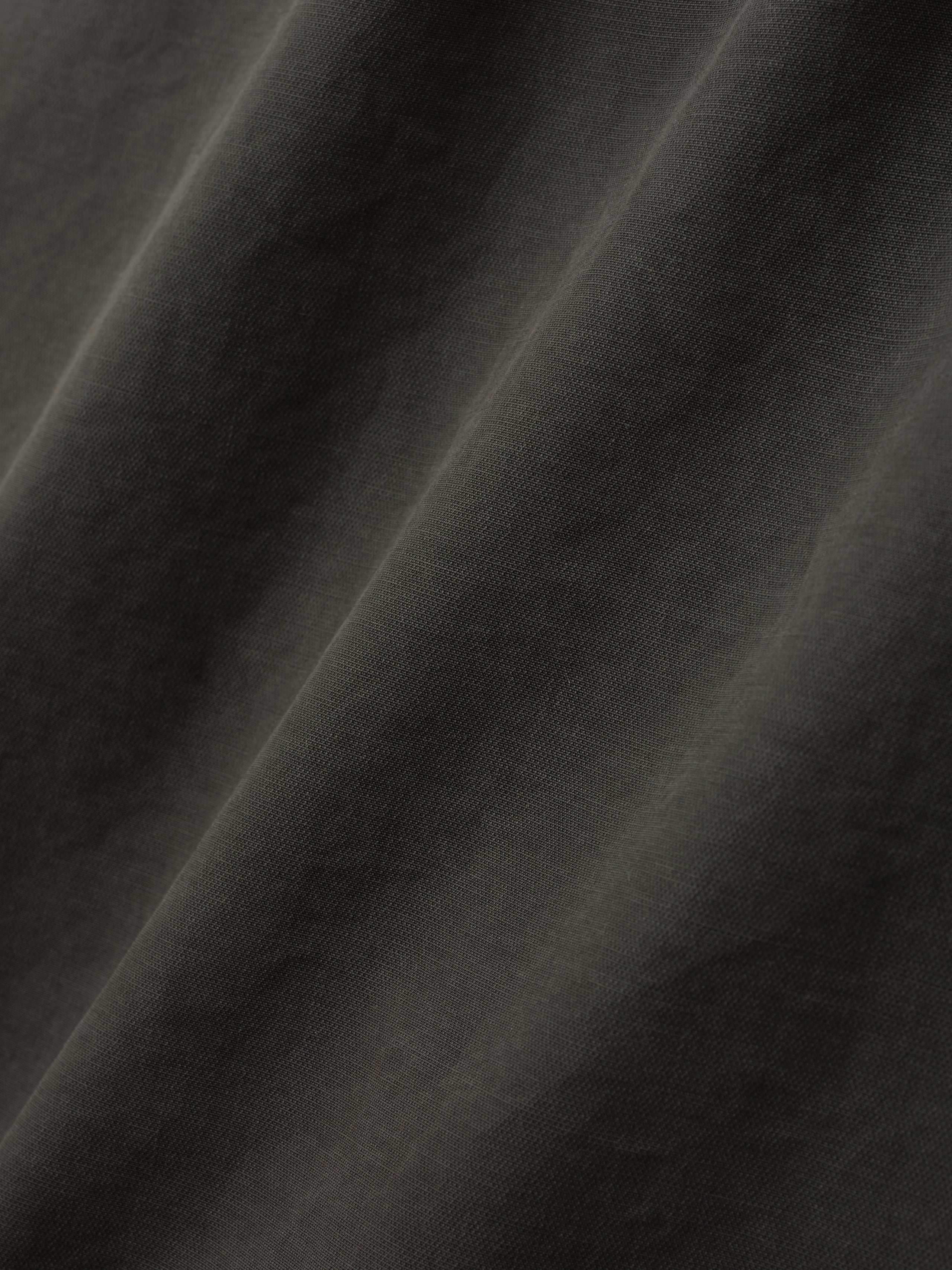 close-up of dark garment dyed heavy double weave cotton fabric with soft texture and subtle folds