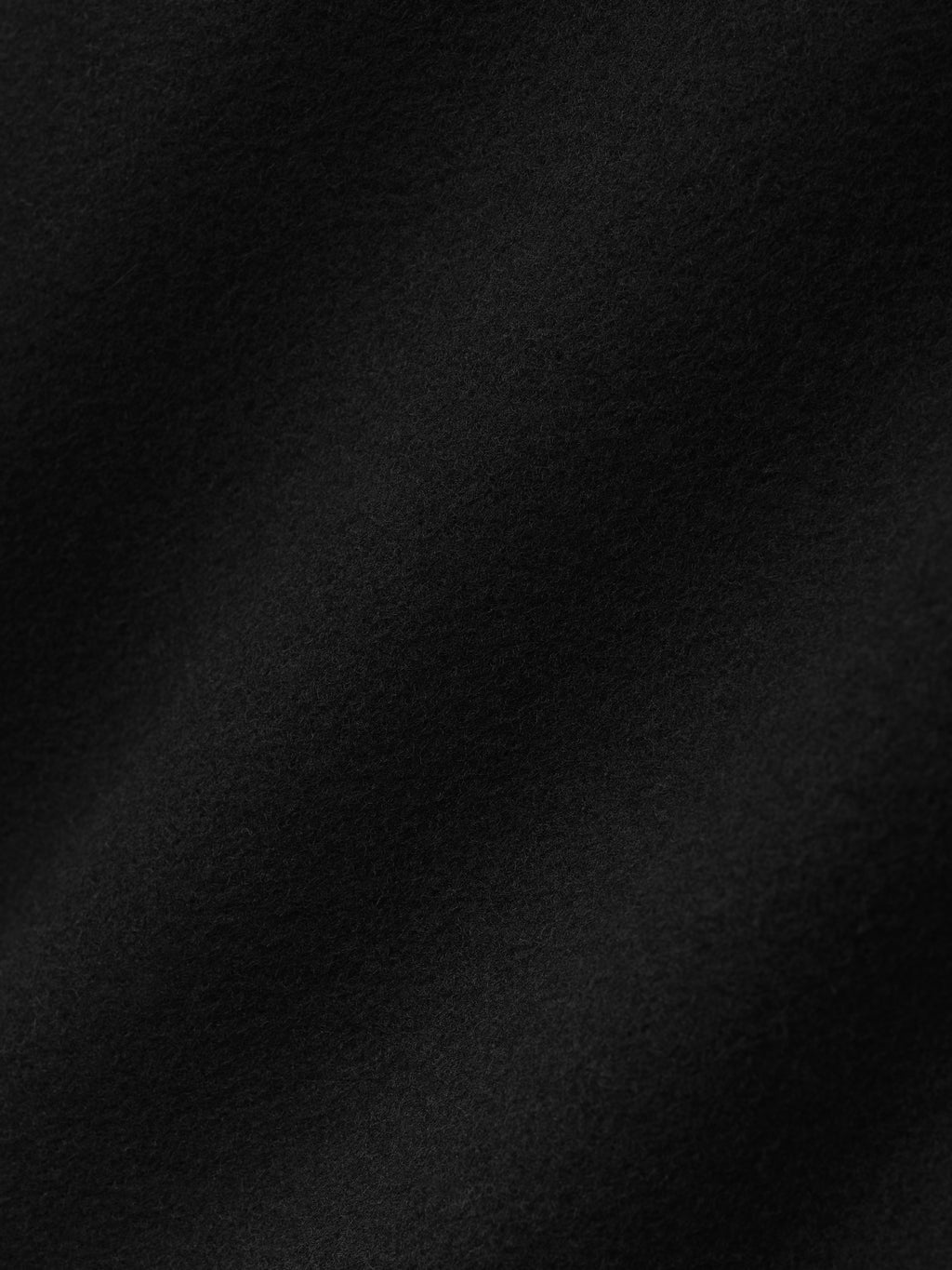 close-up of soft black double-face wool cashmere fabric showing fine texture and subtle surface detail