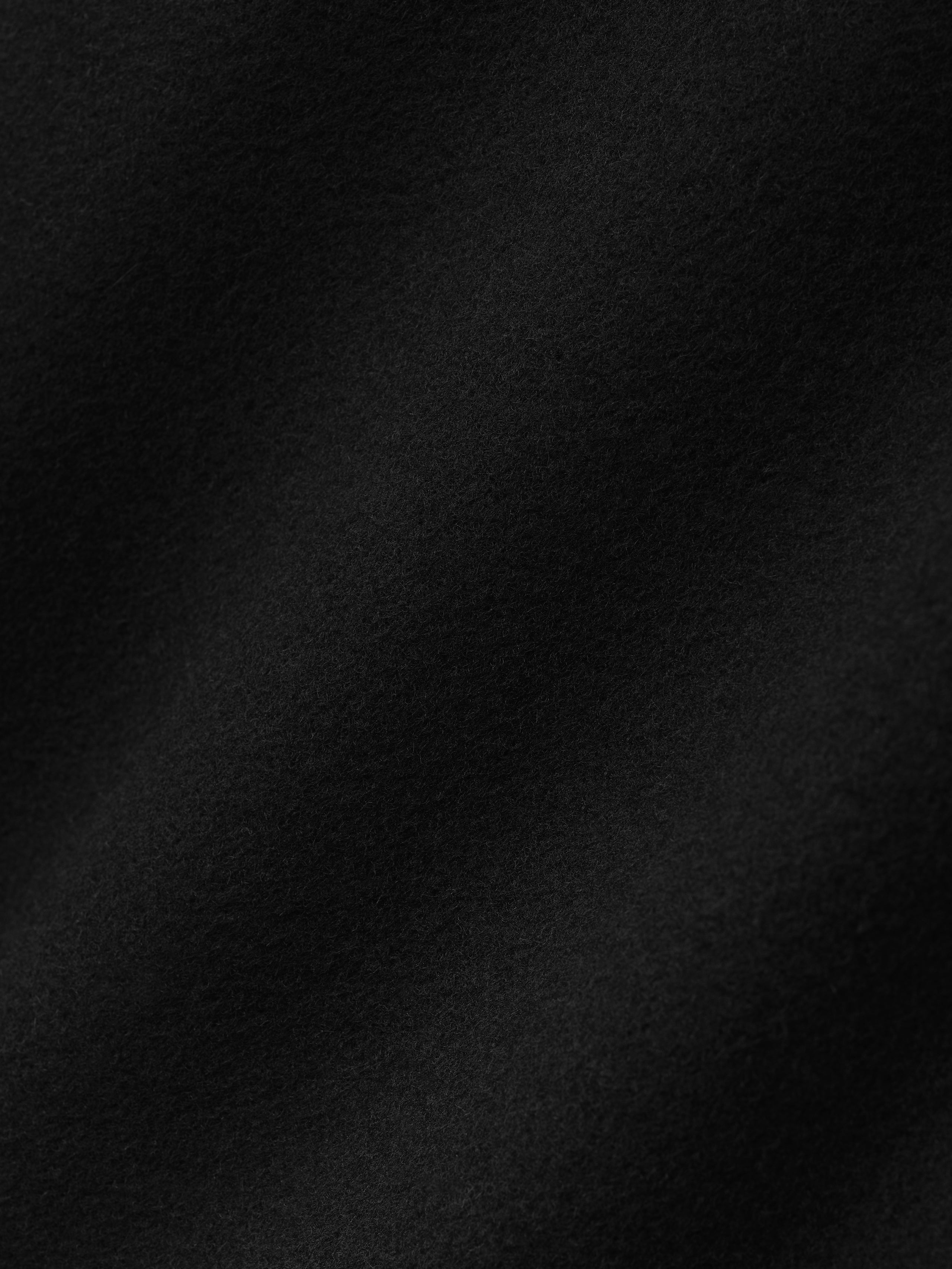 close-up of soft black double-face wool cashmere fabric showing fine texture and subtle surface detail