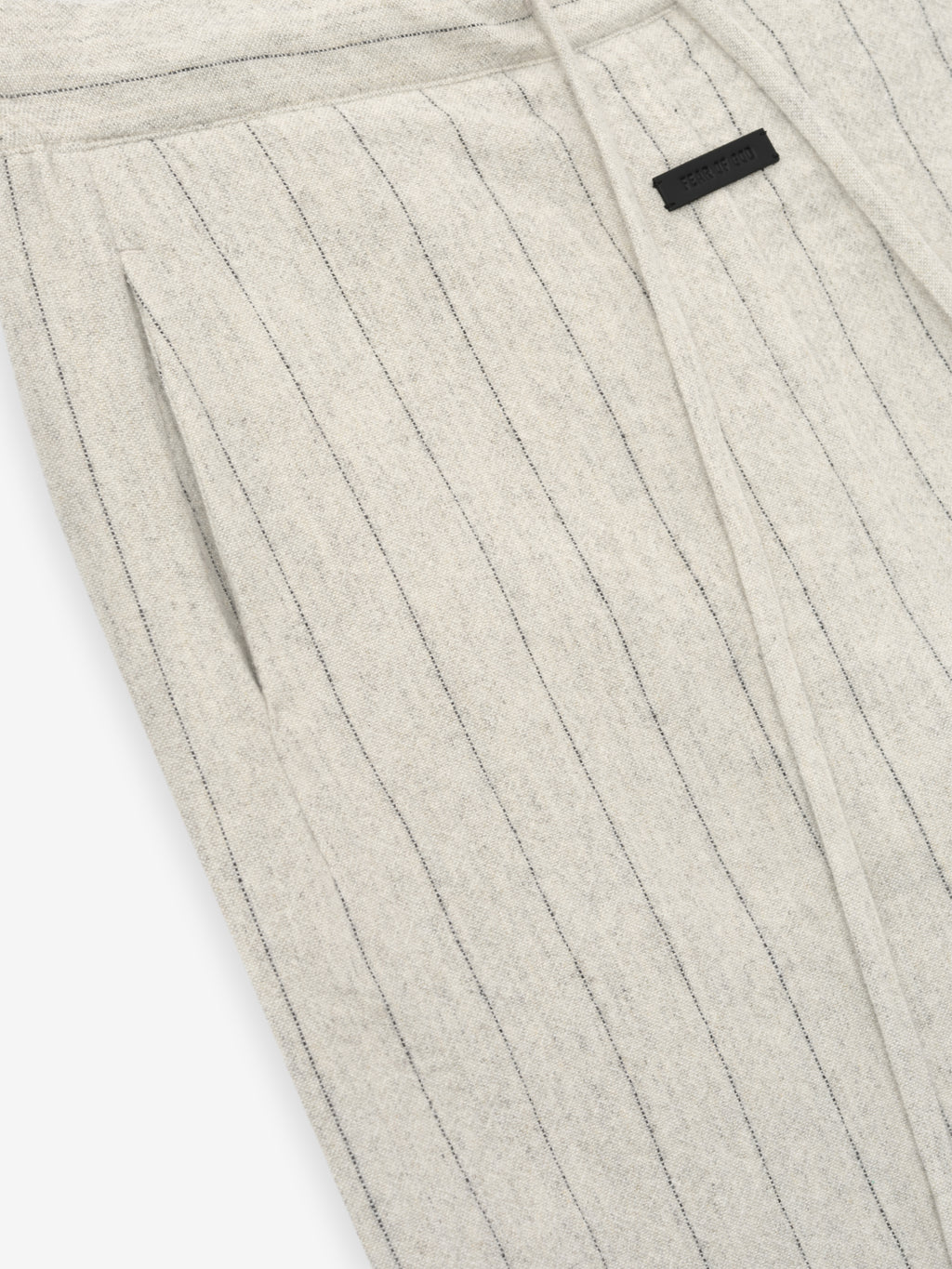 close-up of light beige pinstriped double face wool nylon pants with elasticated waistband and side pockets