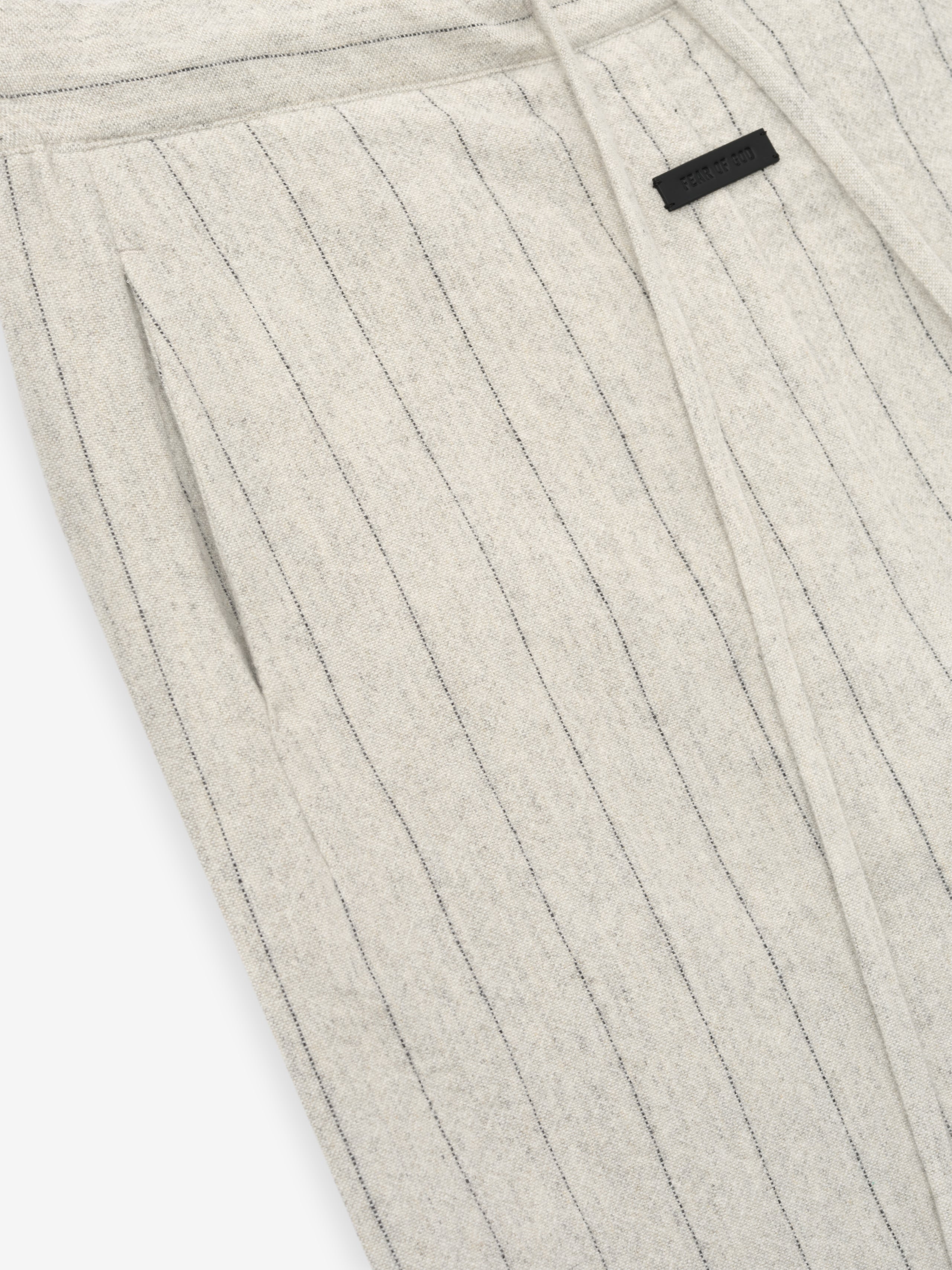 close-up of light beige pinstriped double face wool nylon pants with elasticated waistband and side pockets