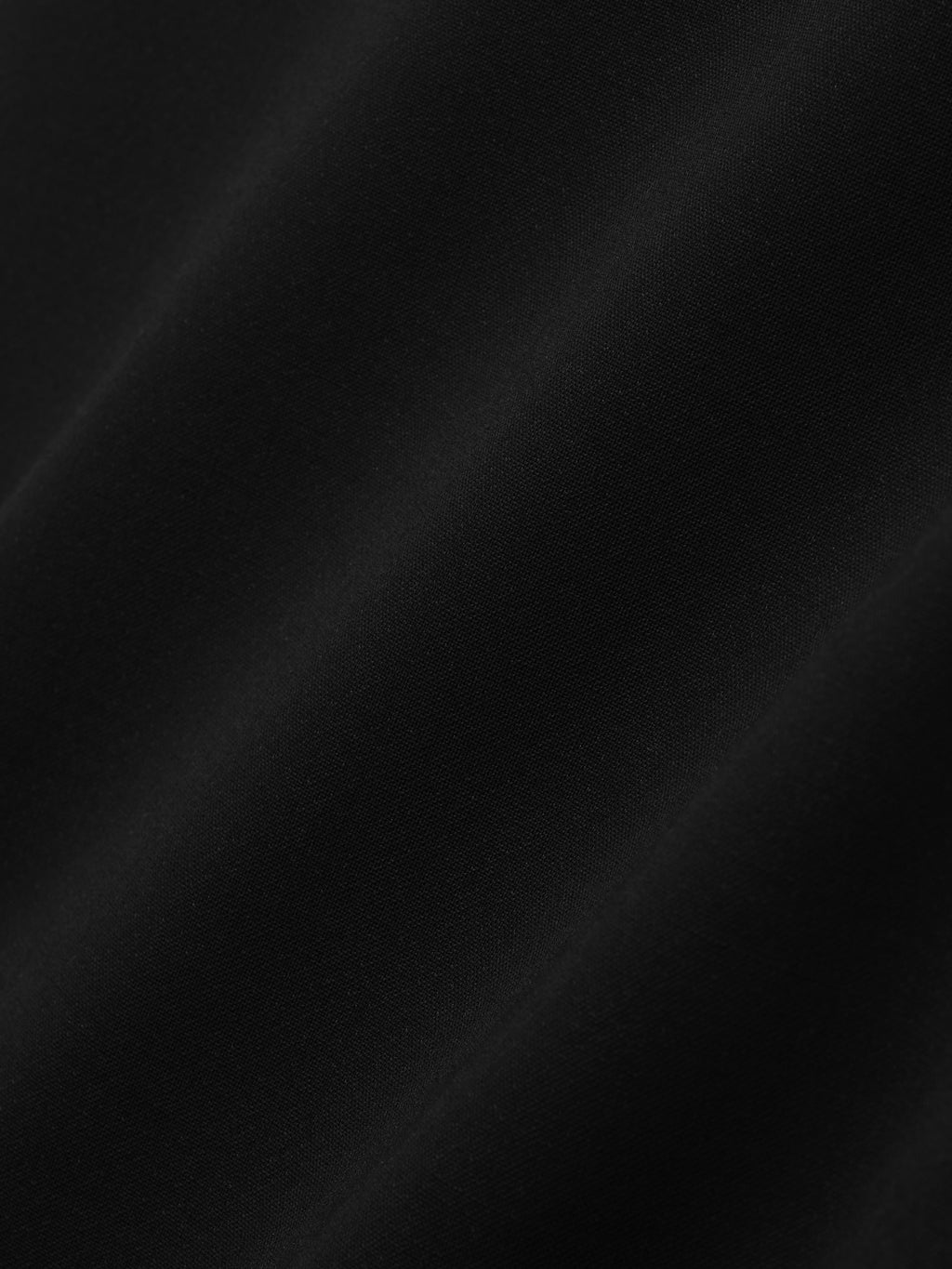 close-up of smooth black double-weave virgin wool fabric with matte finish and soft drape