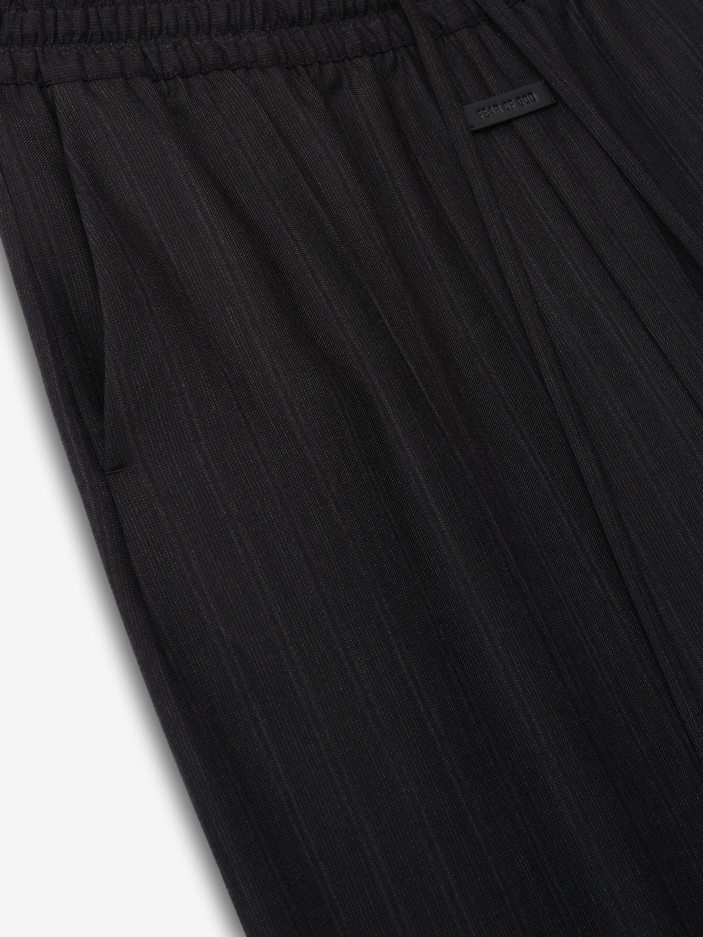 close-up of black striped wool fabric on wide-leg pants with elastic waistband and side pocket detail