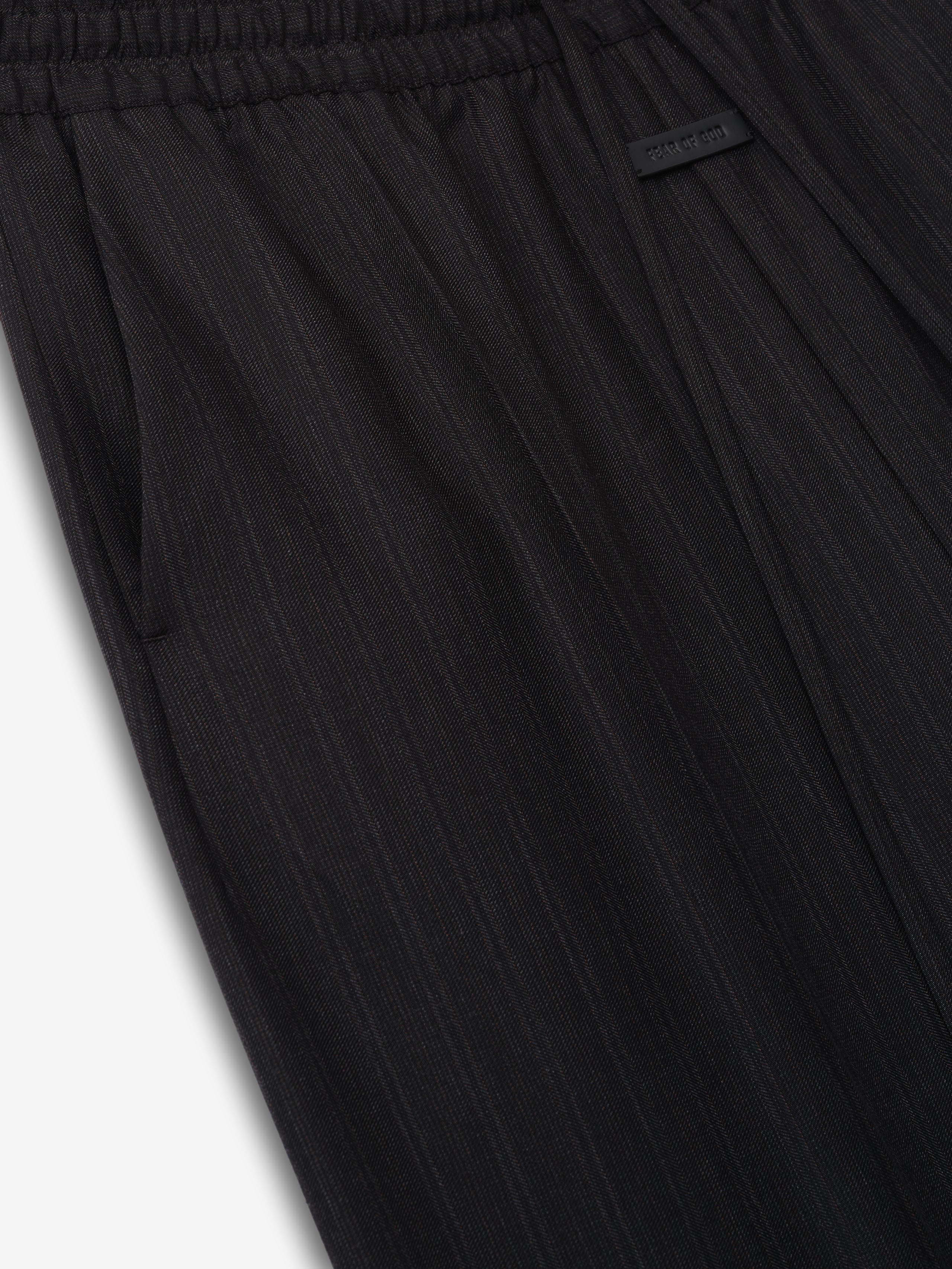 close-up of black striped wool fabric on wide-leg pants with elastic waistband and side pocket detail