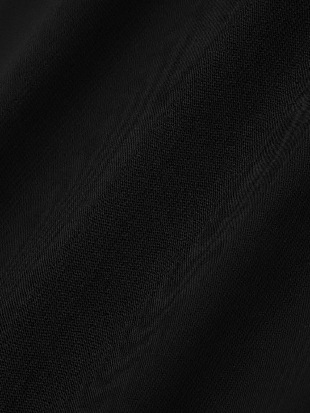 close-up of smooth black superfine lightweight wool canvas fabric with subtle sheen and soft texture
