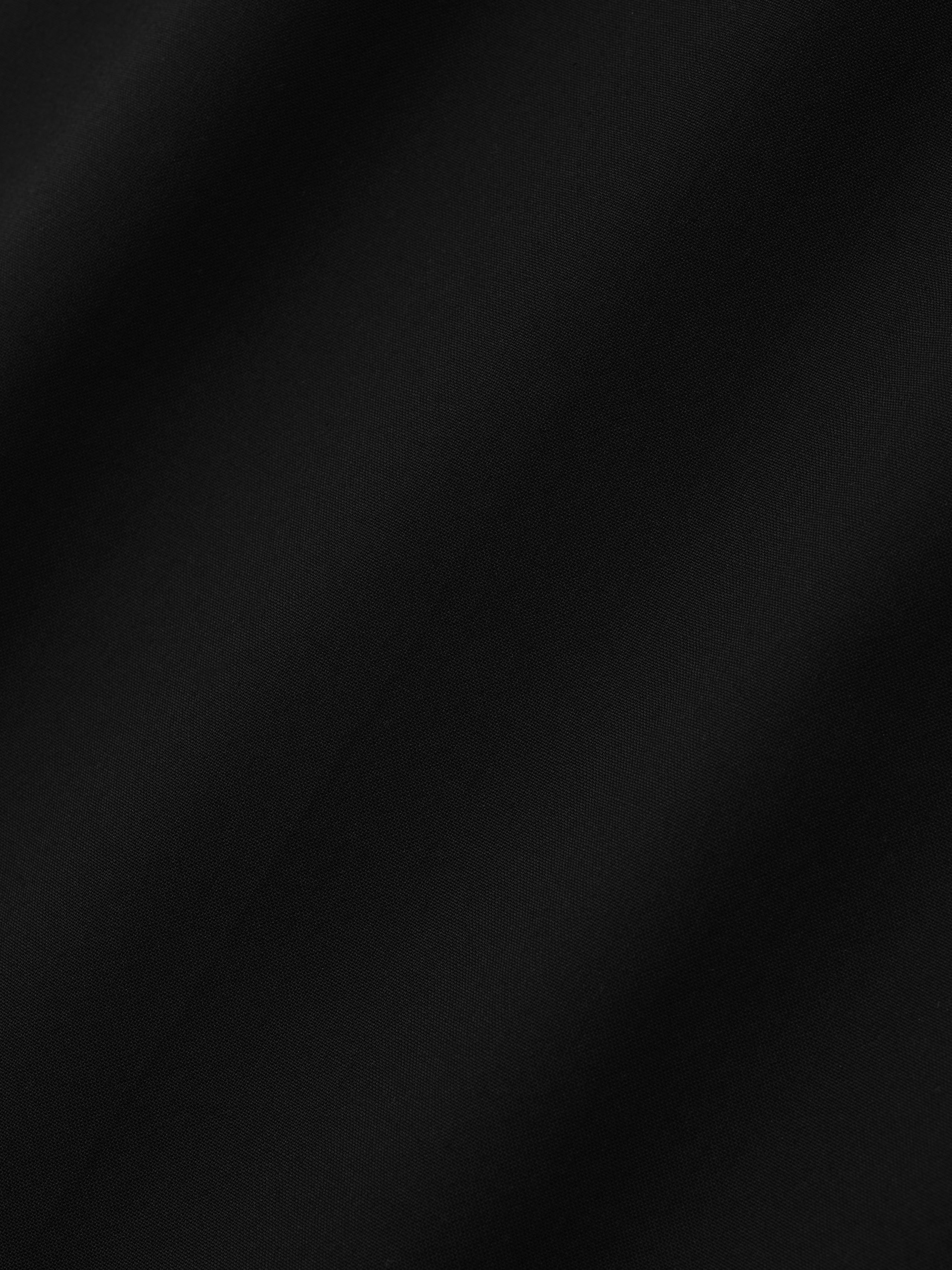 close-up of smooth black superfine lightweight wool canvas fabric with subtle sheen and soft texture