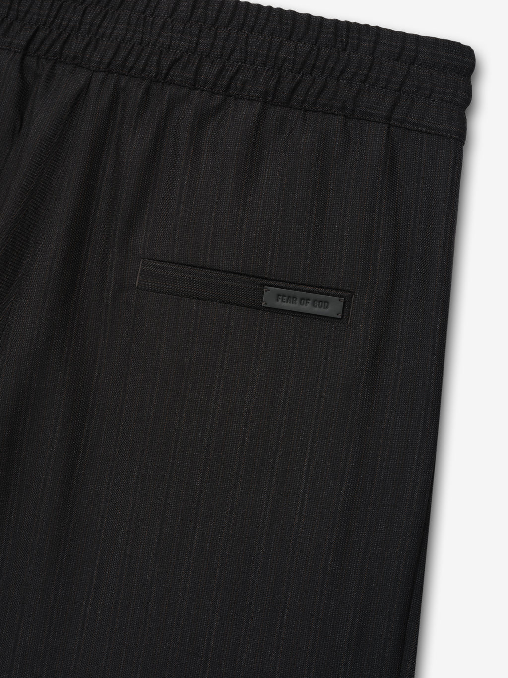 close-up of black striped wool fabric with elastic waistband and rear welt pocket featuring Fear of God label