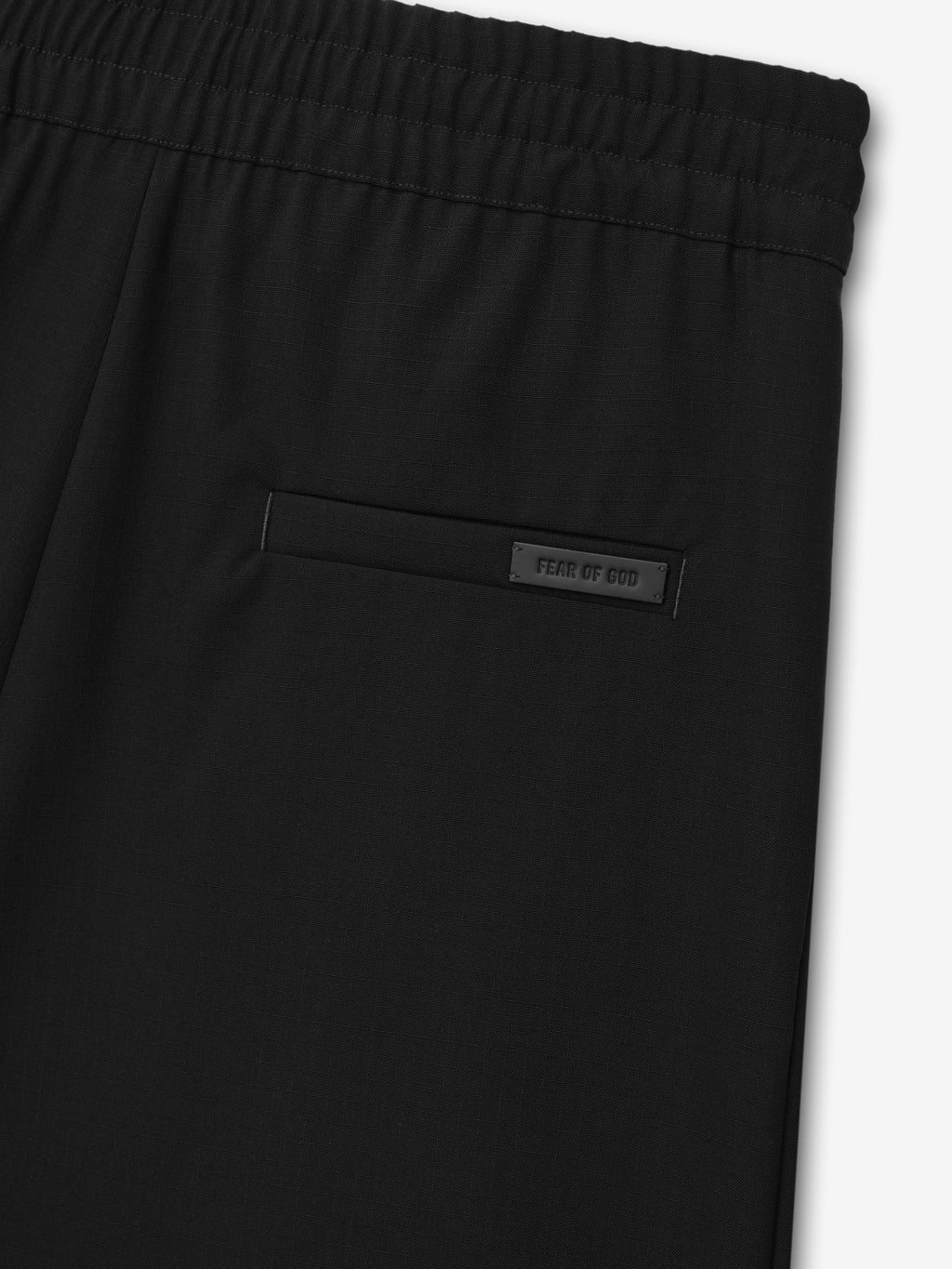 close-up of black ripstop virgin wool fabric with elastic waistband and rear welt pocket featuring Fear of God logo patch