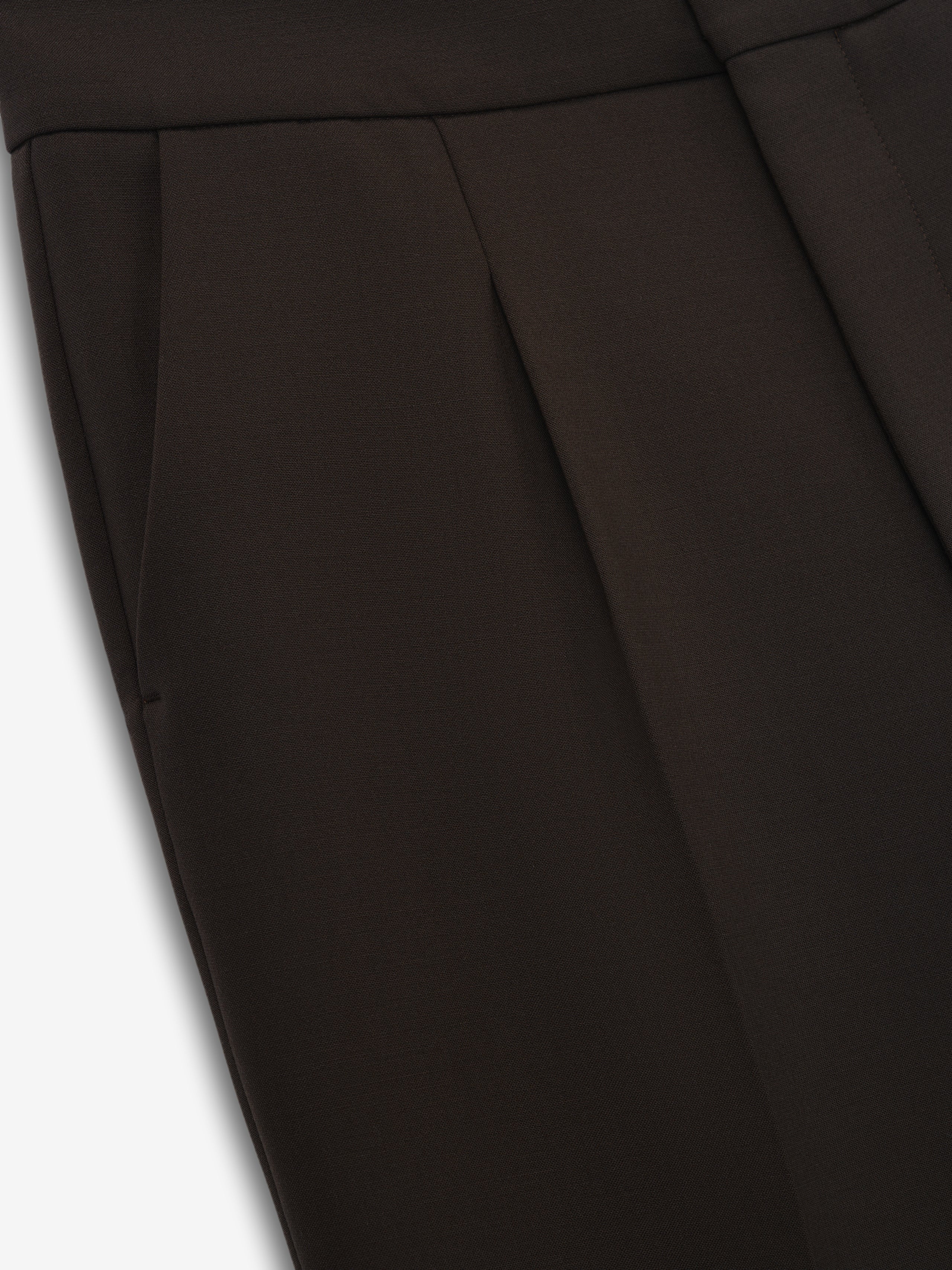 close-up of high-waisted double-weave virgin wool pants with pleats and sleek side pockets in dark brown