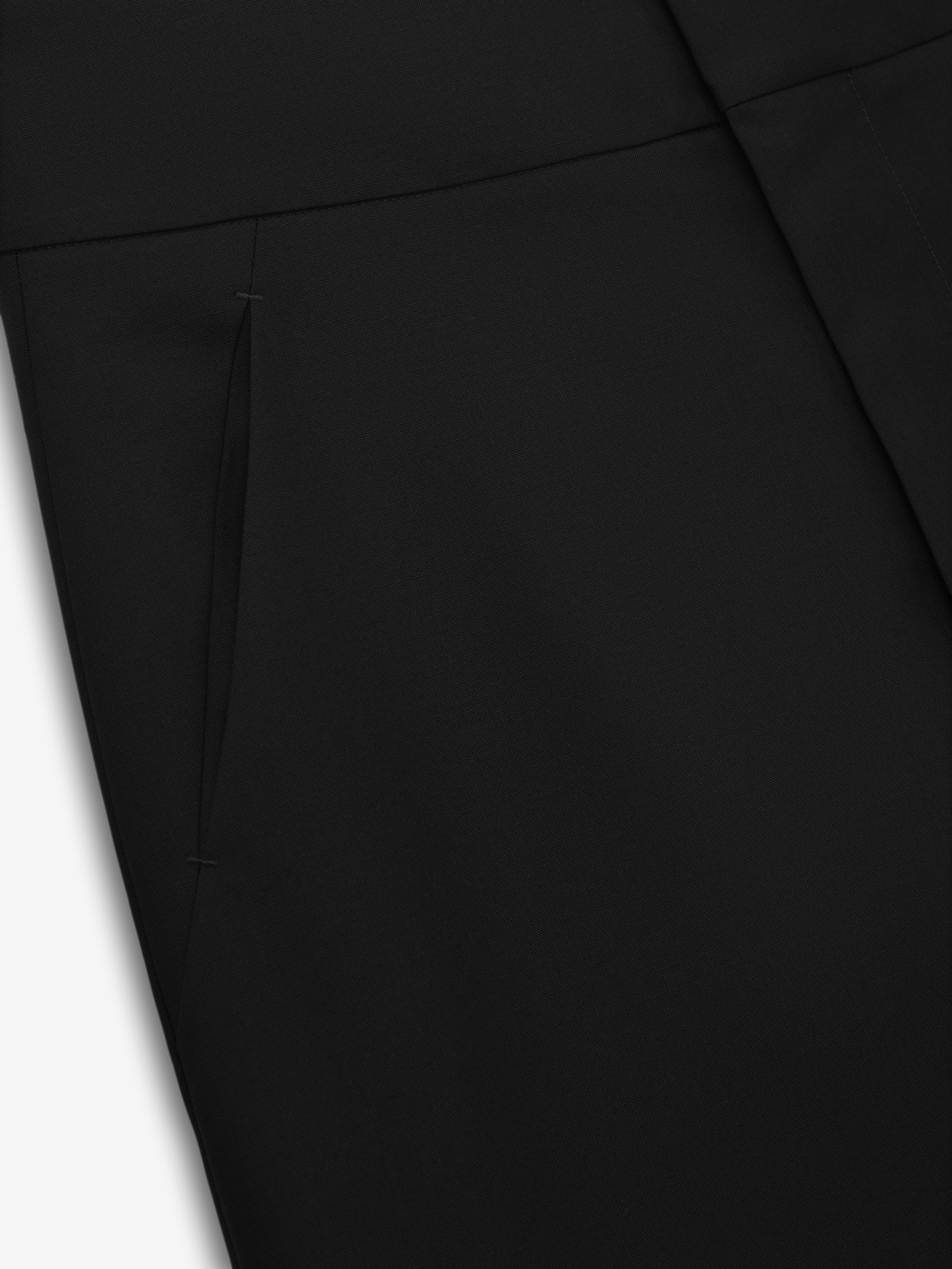 close-up of black wool poplin casual pants highlighting side seam pocket and smooth flat front design