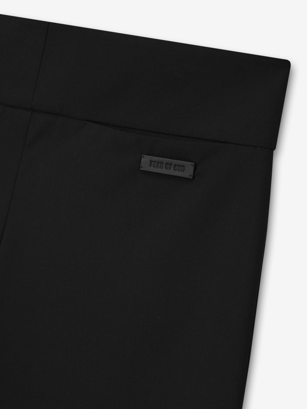 close-up of black wool poplin flat front pants showing waistband detail with subtle Fear of God logo patch