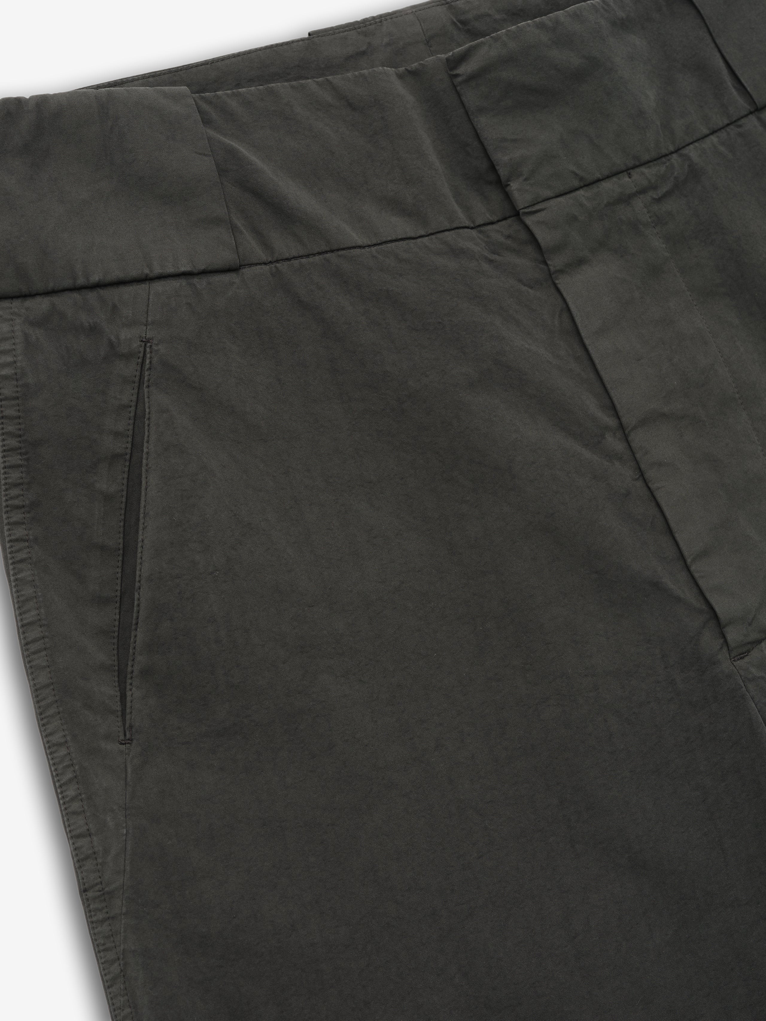 close-up of dark garment-dyed heavy cotton poplin casual short showing waistband and slant front pocket detail