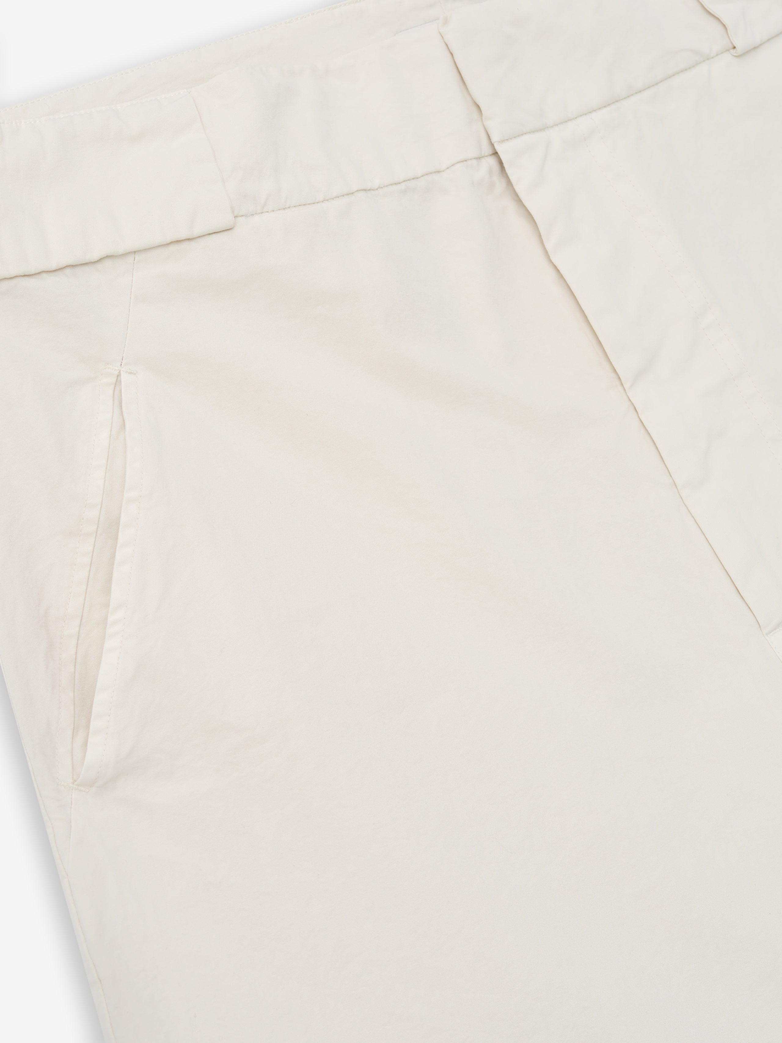 close-up of off-white garment-dyed heavy cotton poplin casual shorts with slant front pocket and waistband detail