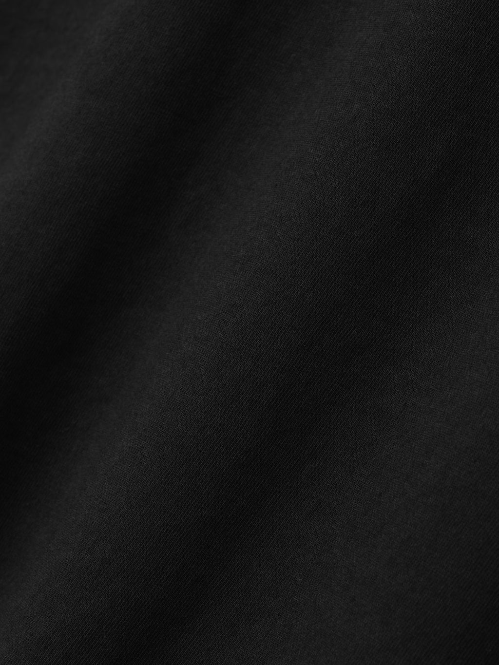 Close-up of soft black fabric texture with subtle natural folds and smooth surface detail