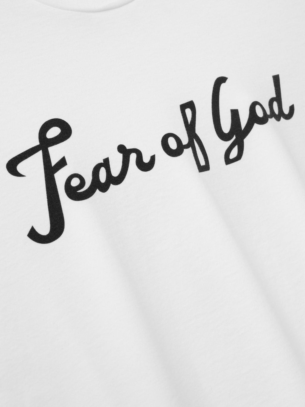 Close-up of white fabric with black cursive lettering spelling "Fear of God" printed across the surface