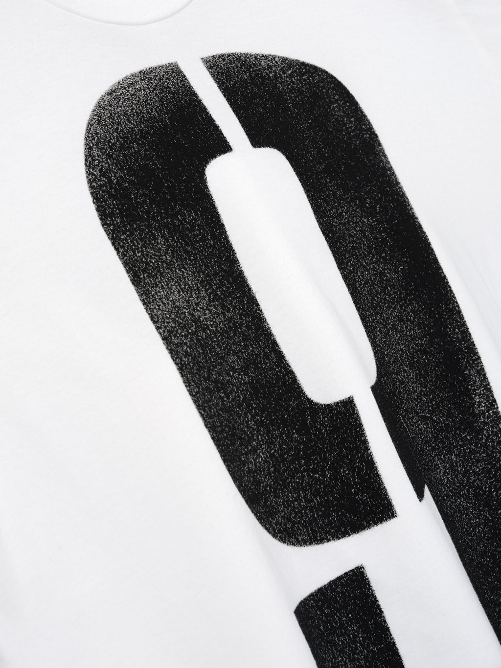 Close-up of a white fabric with a large black distressed number zero graphic printed on it