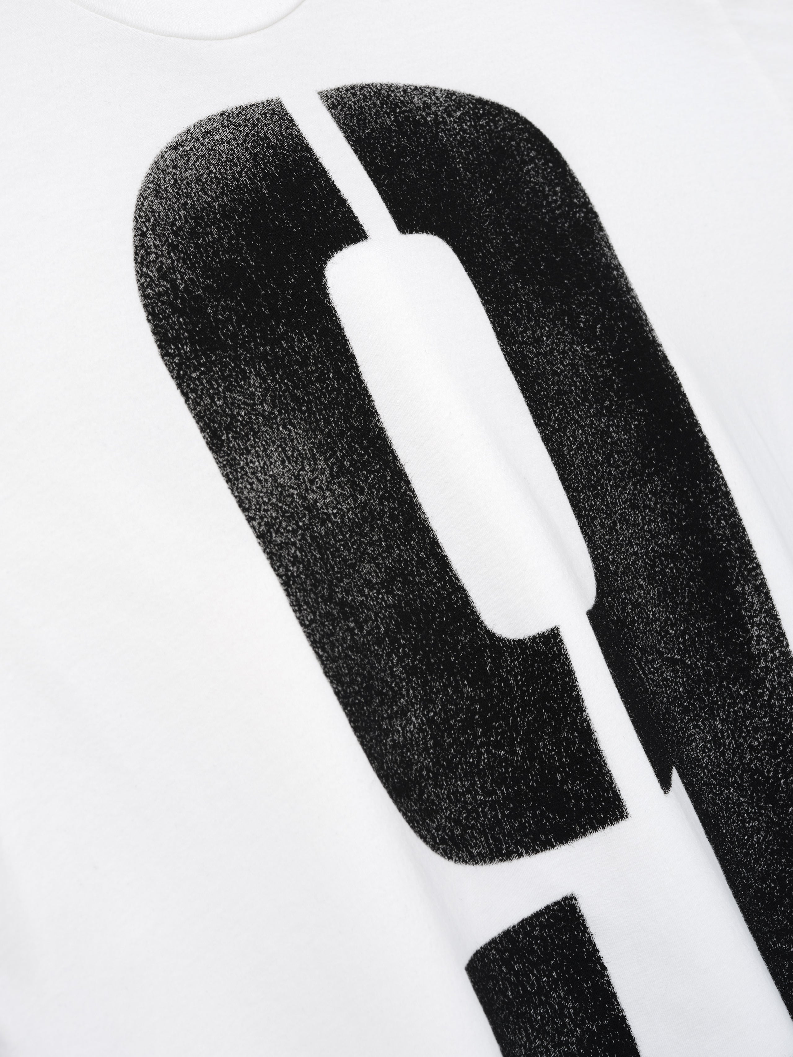 Close-up of a white fabric with a large black distressed number zero graphic printed on it