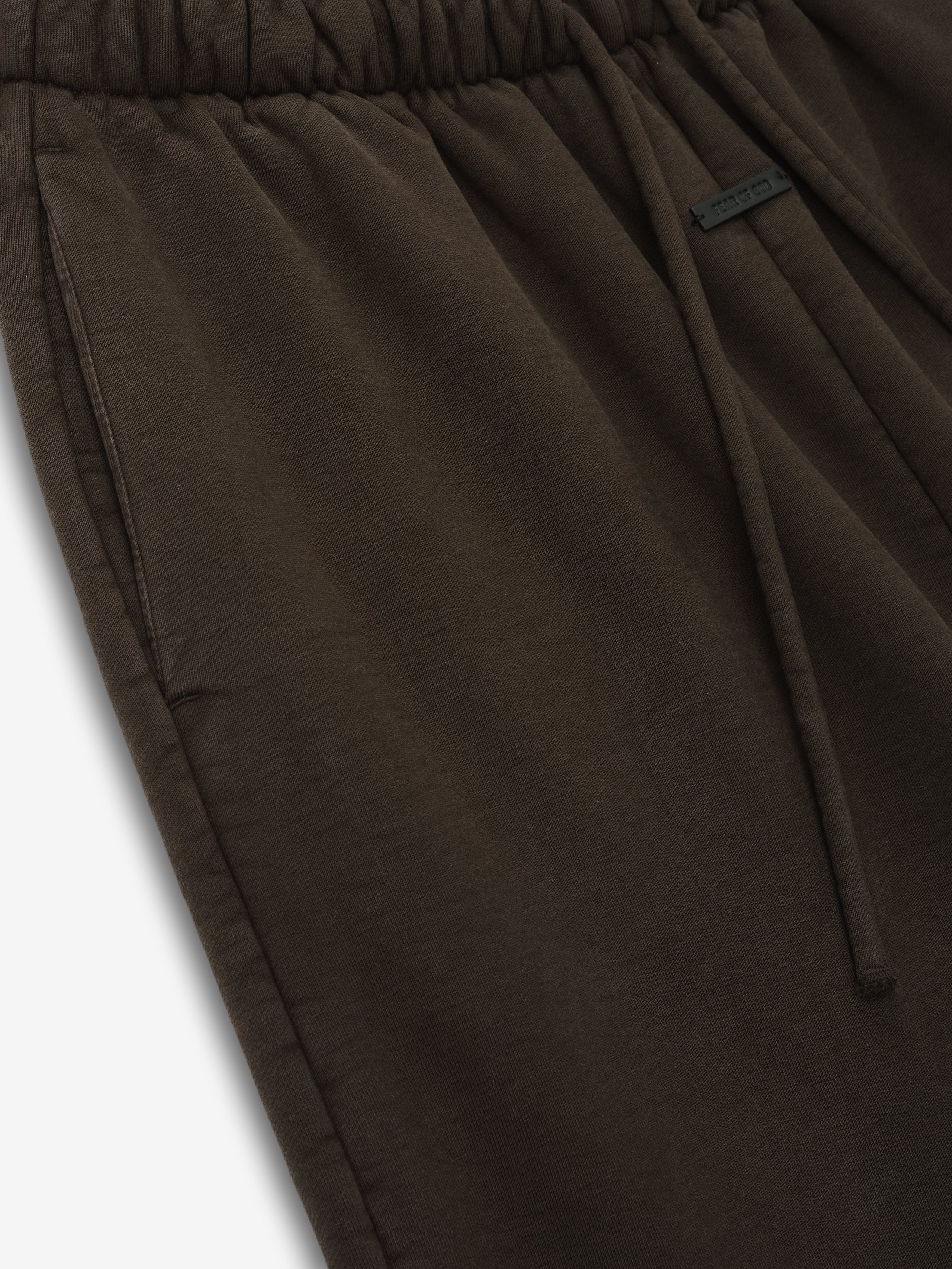 close-up of dark brown heavyweight cotton fleece fabric with elastic waistband and drawstring on womens sweatpants