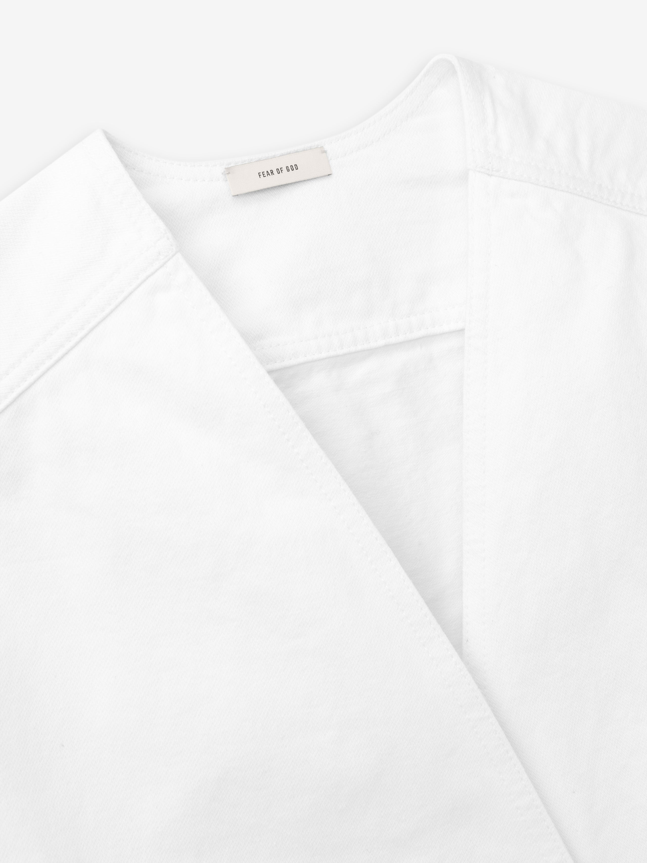 close-up of optic white cotton broken twill fabric and collar detail on relaxed lapelless denim jacket