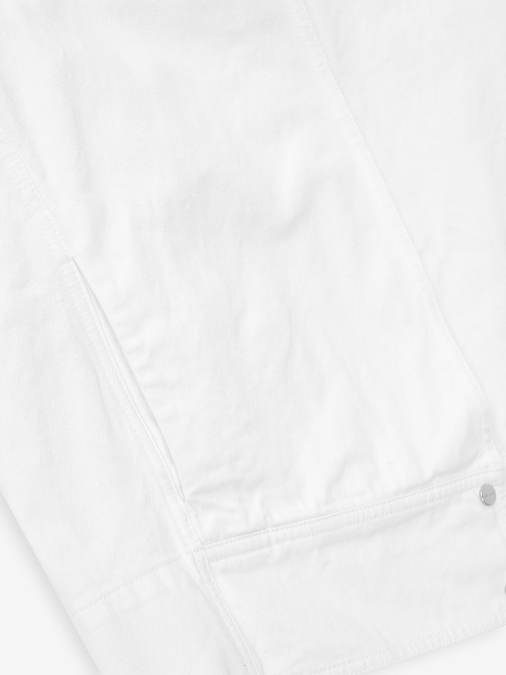 detailed view of optic white cotton broken twill fabric with snap button and pocket stitching on relaxed jacket