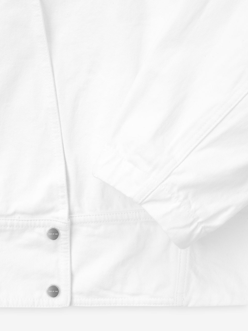 close-up of optic white cotton broken twill fabric with snap buttons and cuff detail on relaxed lapelless jacket