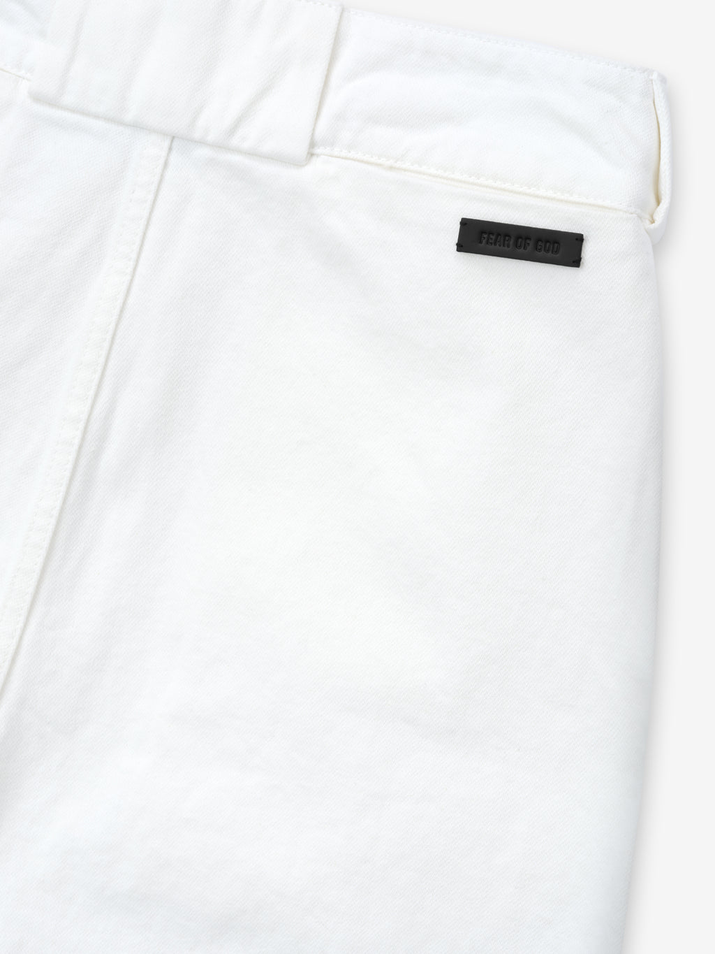 close-up of optic white cotton broken twill fabric with belt loop and black Fear of God logo patch on women's utility pant