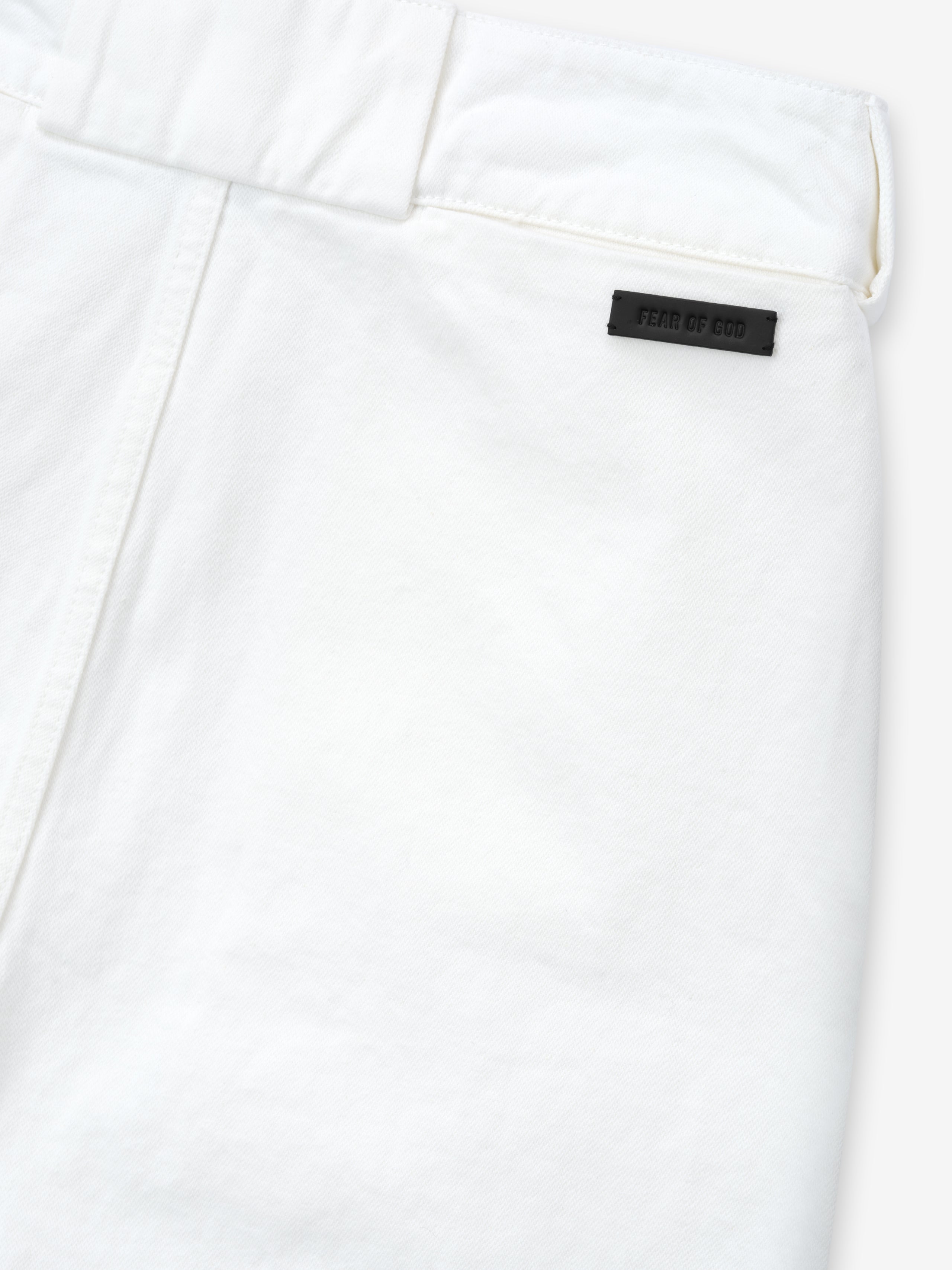 close-up of optic white cotton broken twill fabric with belt loop and black Fear of God logo patch on women's utility pant