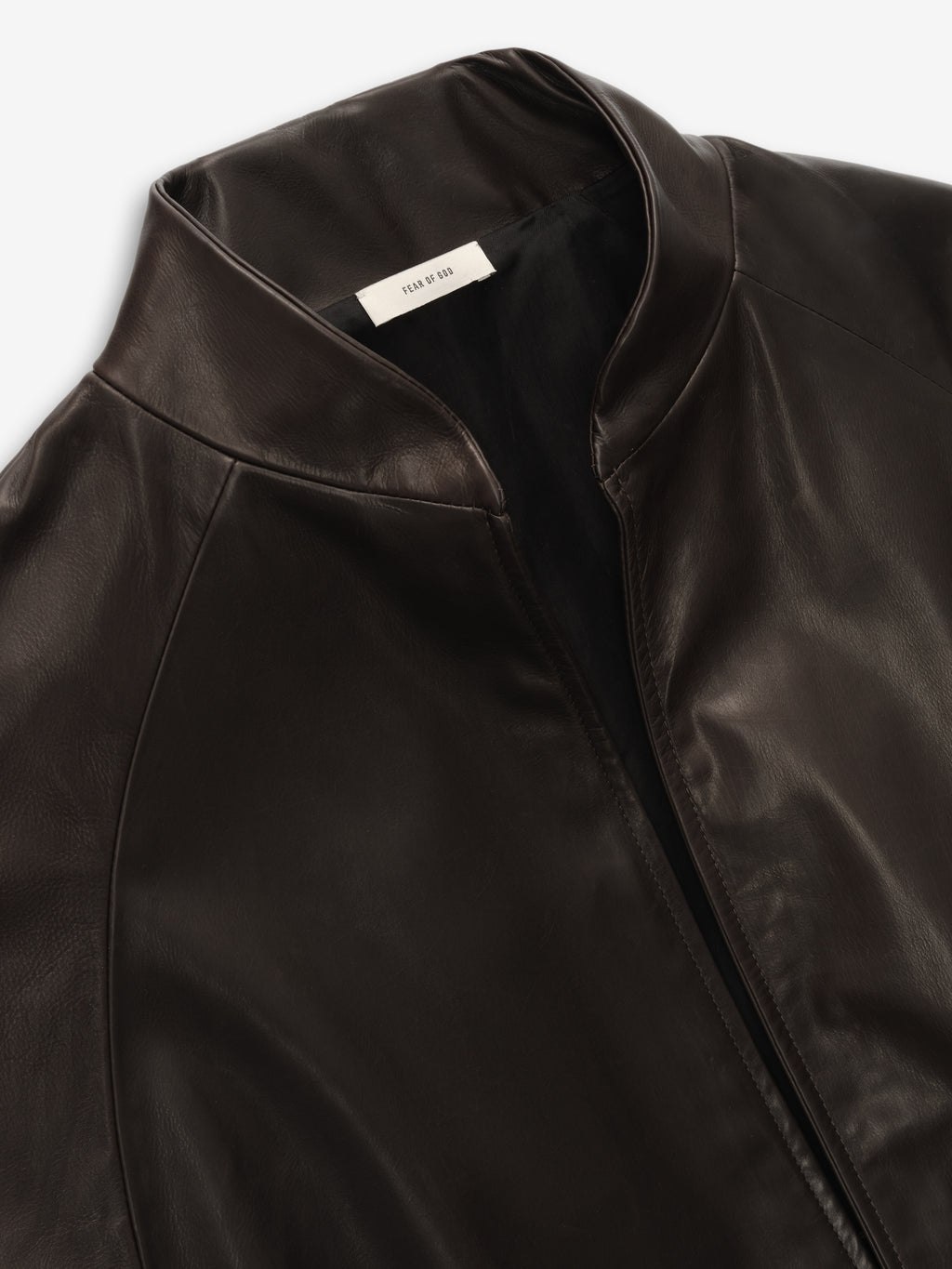 close-up of dark brown full-grain calfskin leather coat with baseball collar and smooth finish for women