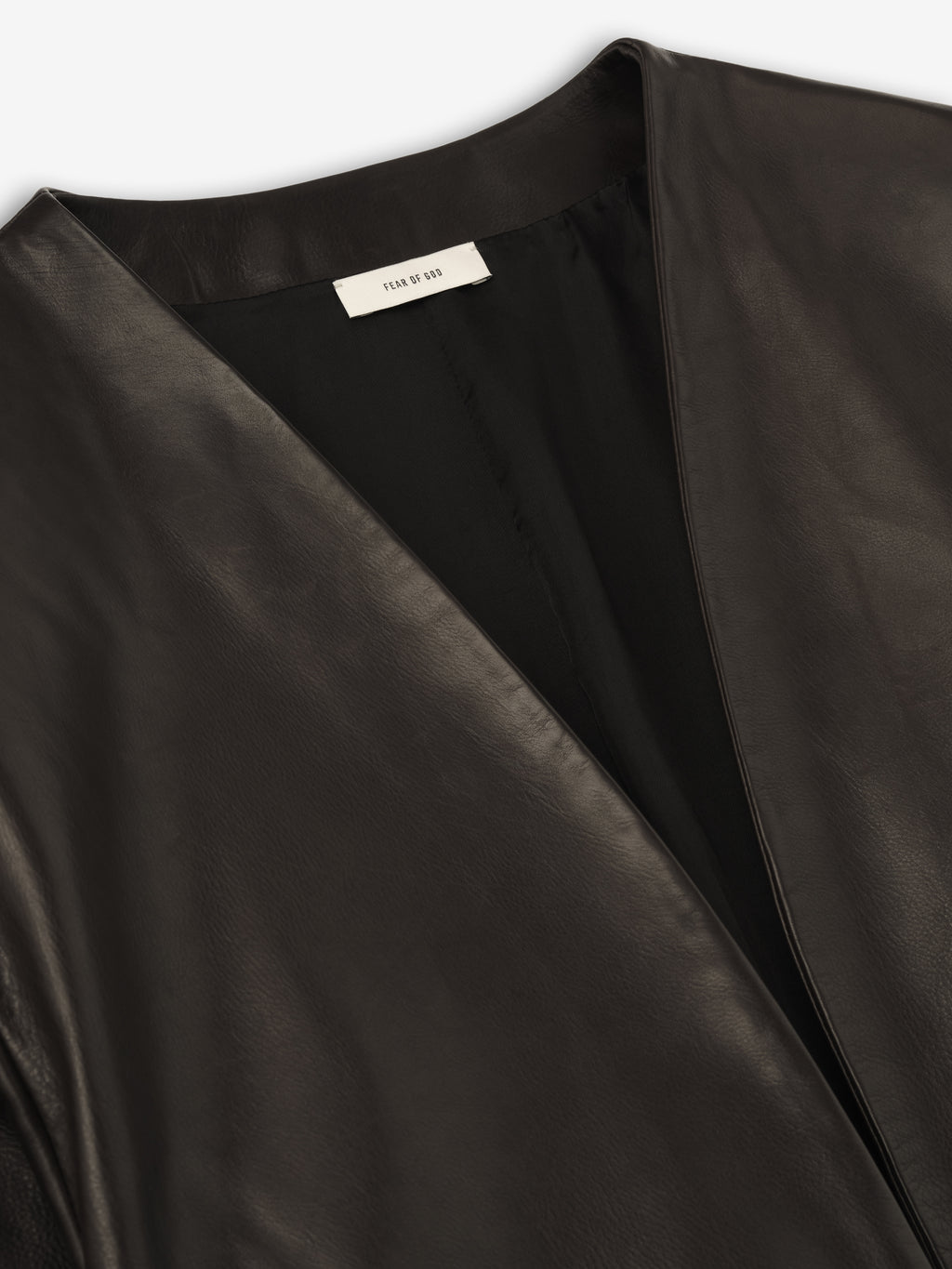 close-up of black full-grain calfskin leather collarless jacket with smooth finish and subtle inner lining for women