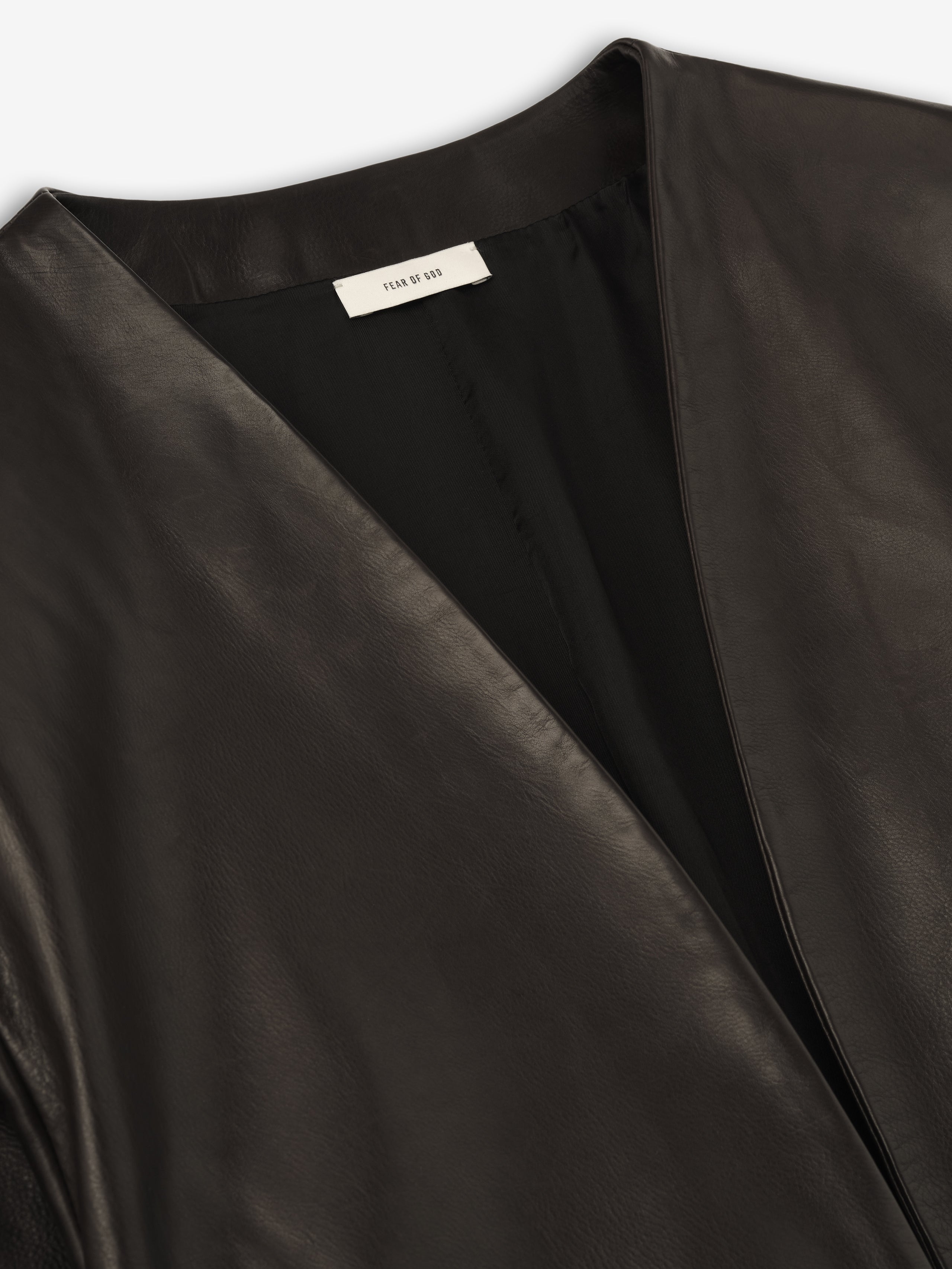 close-up of black full-grain calfskin leather collarless jacket with smooth finish and subtle inner lining for women