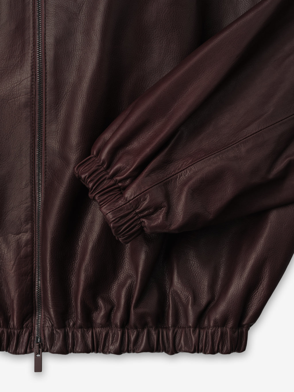 close-up of burgundy full-grain calfskin leather track jacket with elasticated cuffs, hem, and front zipper closure