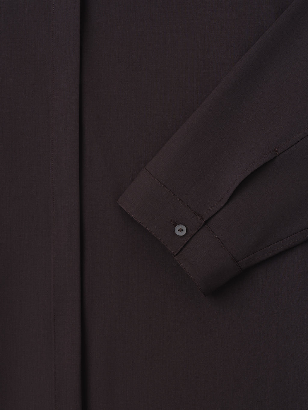 close-up of dark relaxed fit women's shirt sleeve with small buttoned cuff and hidden front placket in lightweight wool canvas