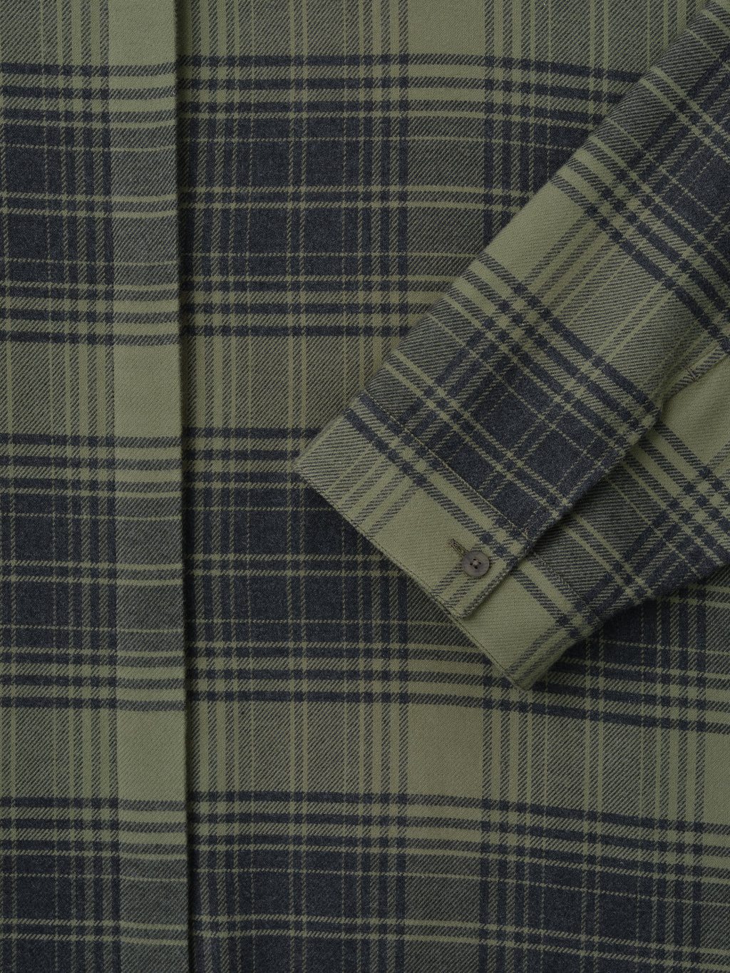close-up of green plaid cotton flannel women's shirt sleeve with small buttoned cuff and concealed front placket