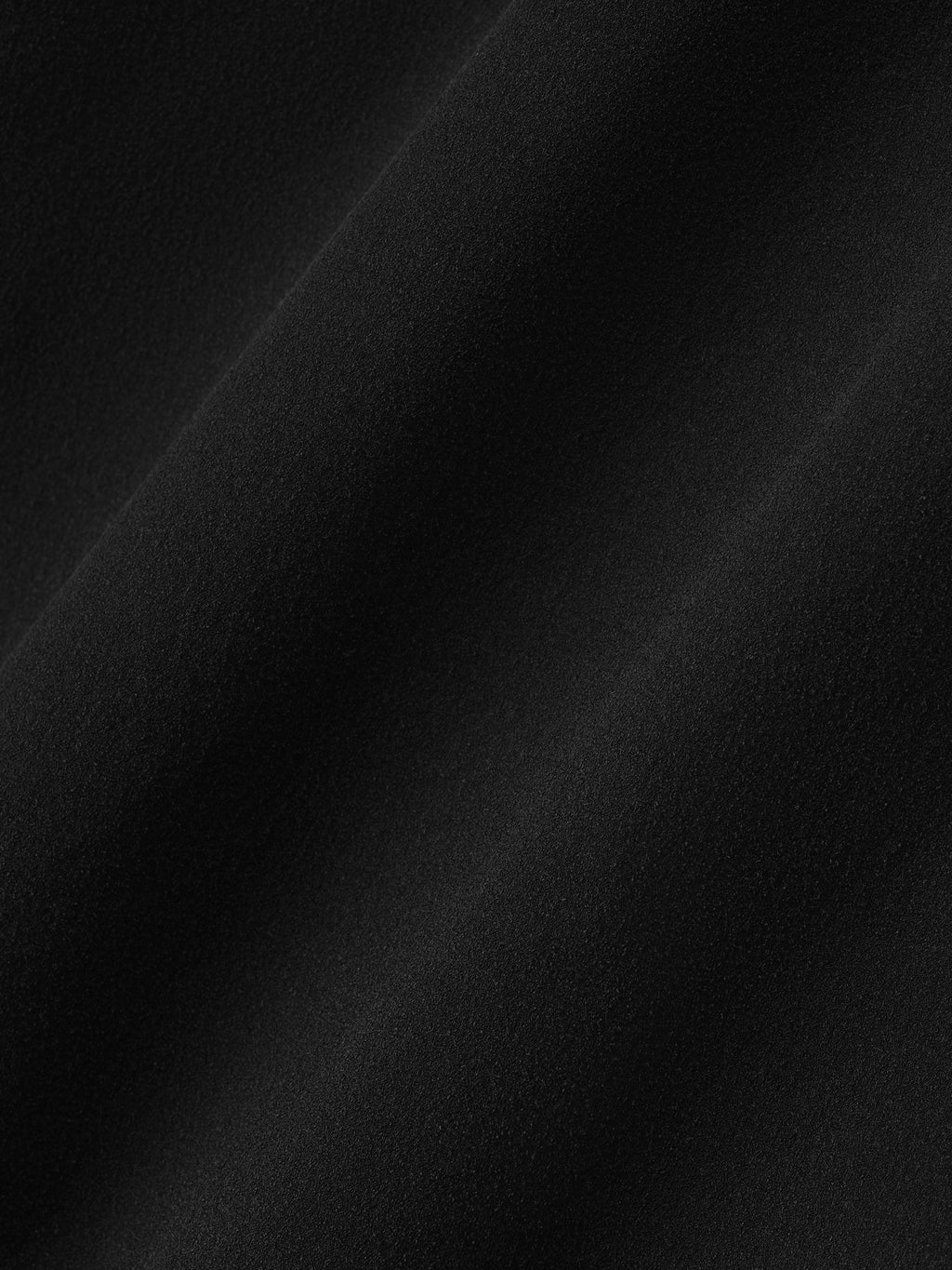 close-up of black slightly sheer silk elastane fabric with smooth texture and subtle drape detail