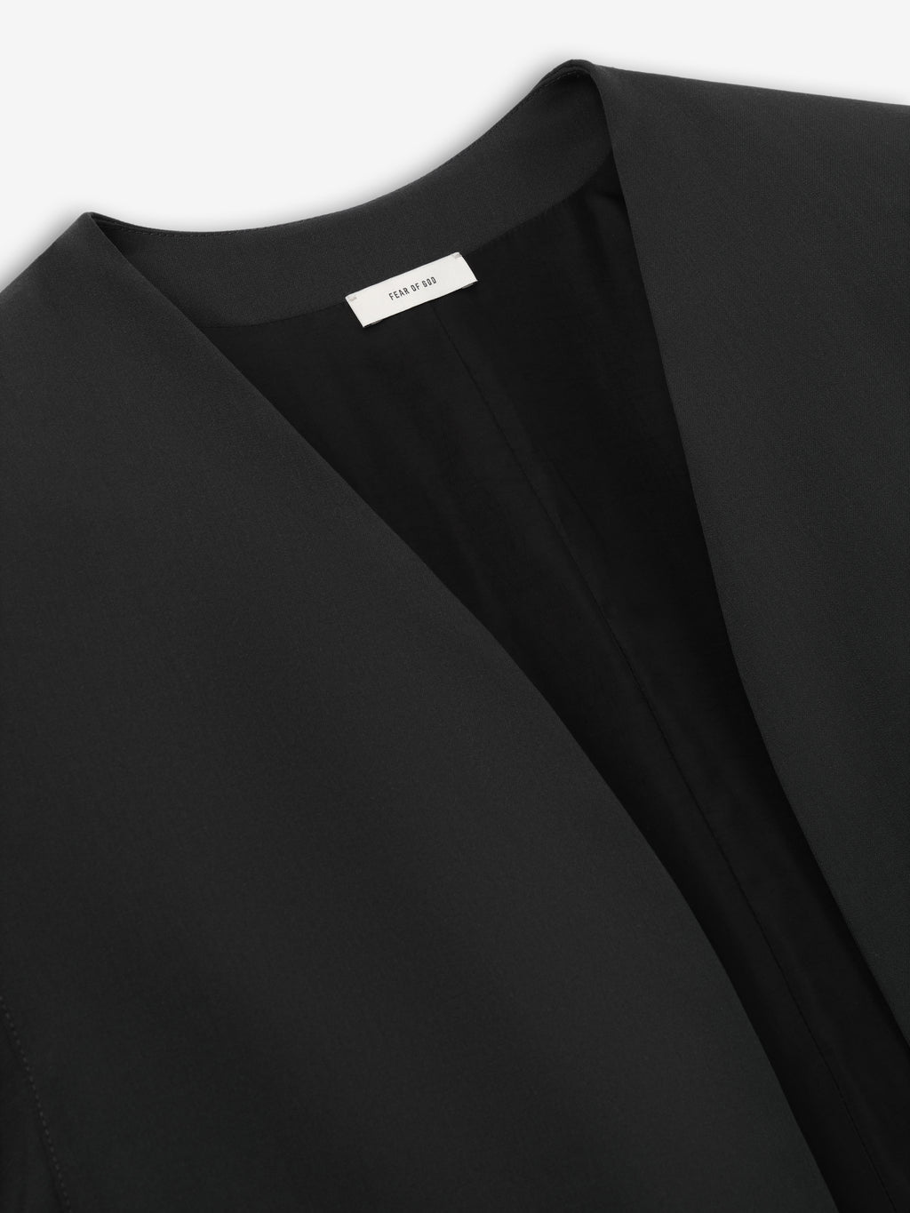 close-up of black collarless jacket neckline with smooth fabric and clean, sharp edges on lightweight material