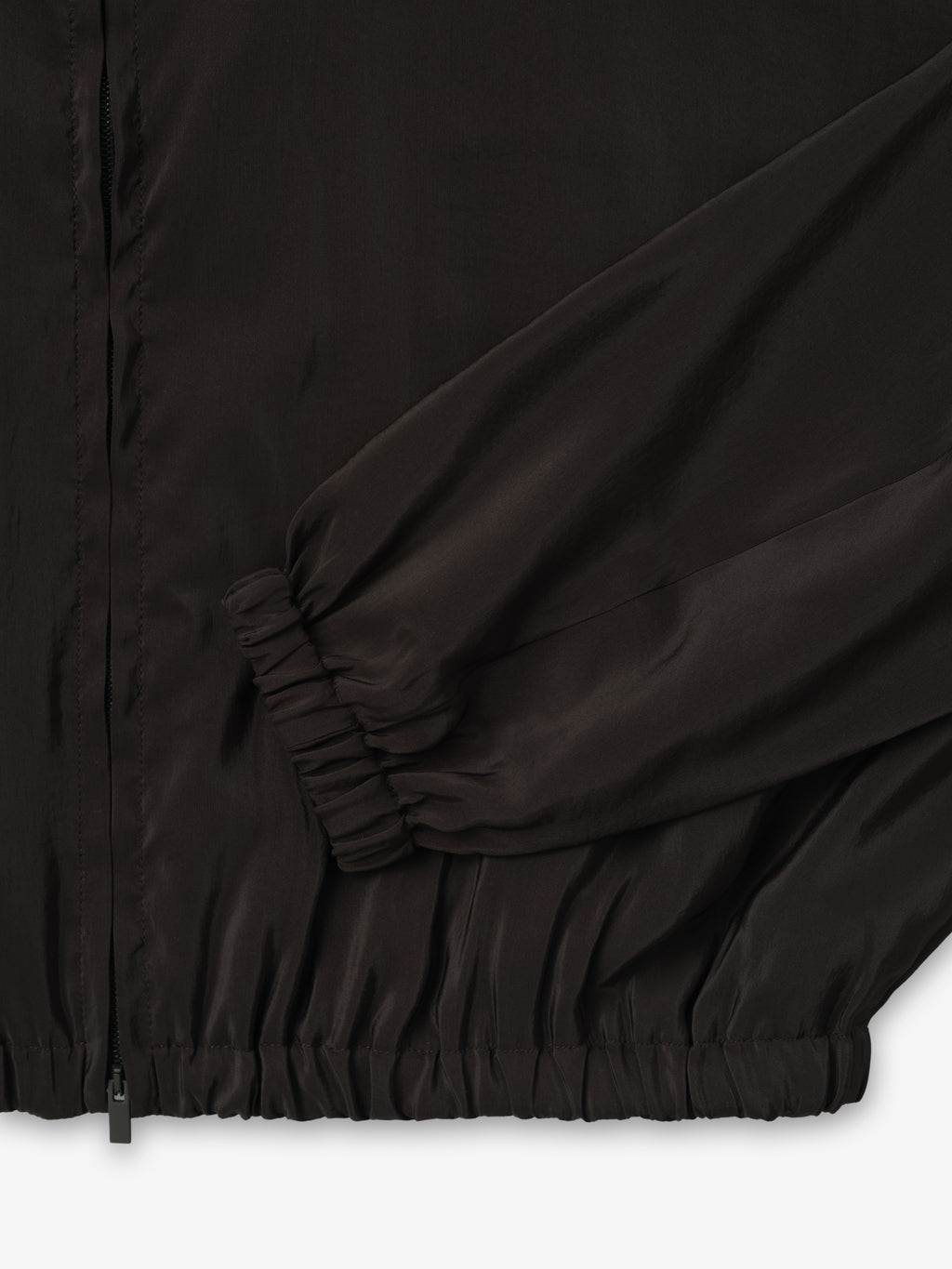 close-up of black lightweight crinkle viscose track jacket cuff and hem with elasticated ribbing and smooth matte finish