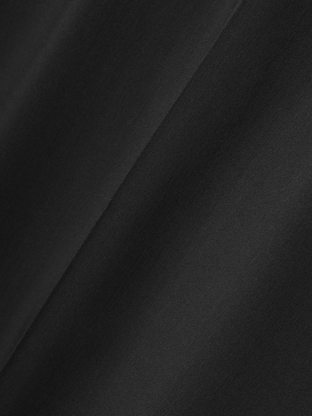 close-up of smooth black fabric with subtle diagonal texture detail on wide leg pants