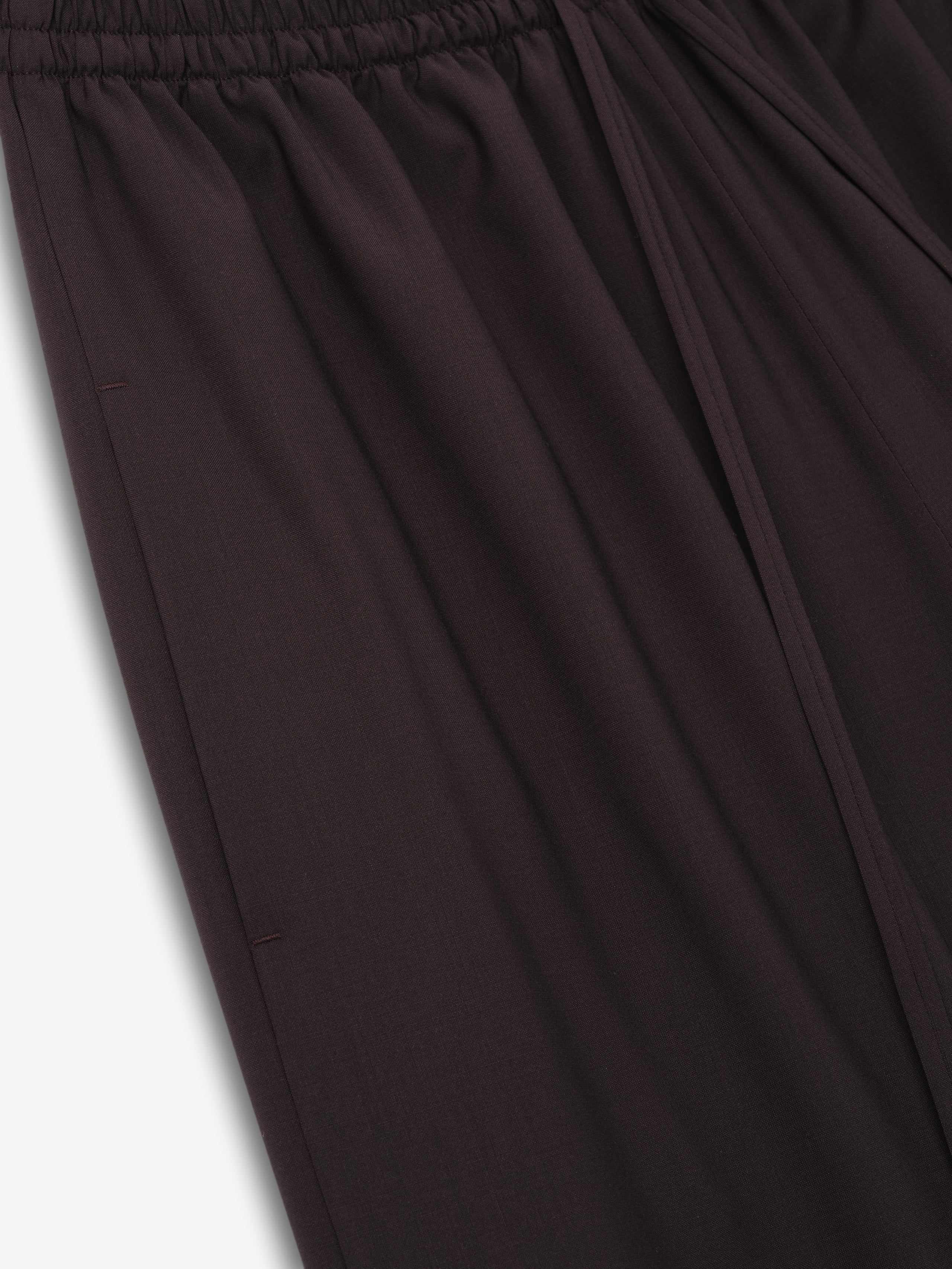 close-up of dark superfine wool canvas drawstring pants with elasticated waistband and relaxed wide-leg fit for women