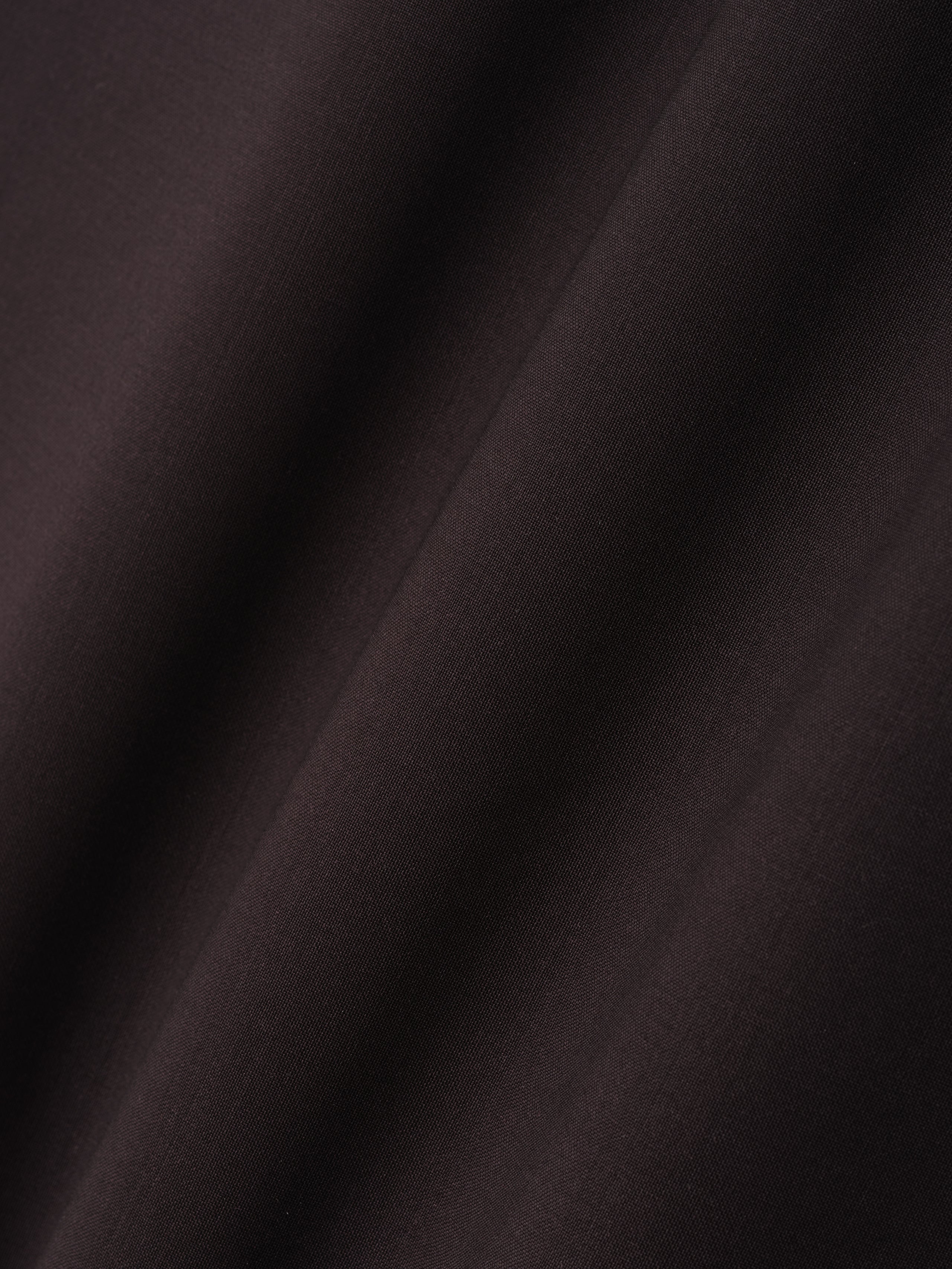 close-up of dark superfine wool canvas fabric with smooth texture and soft drape detail