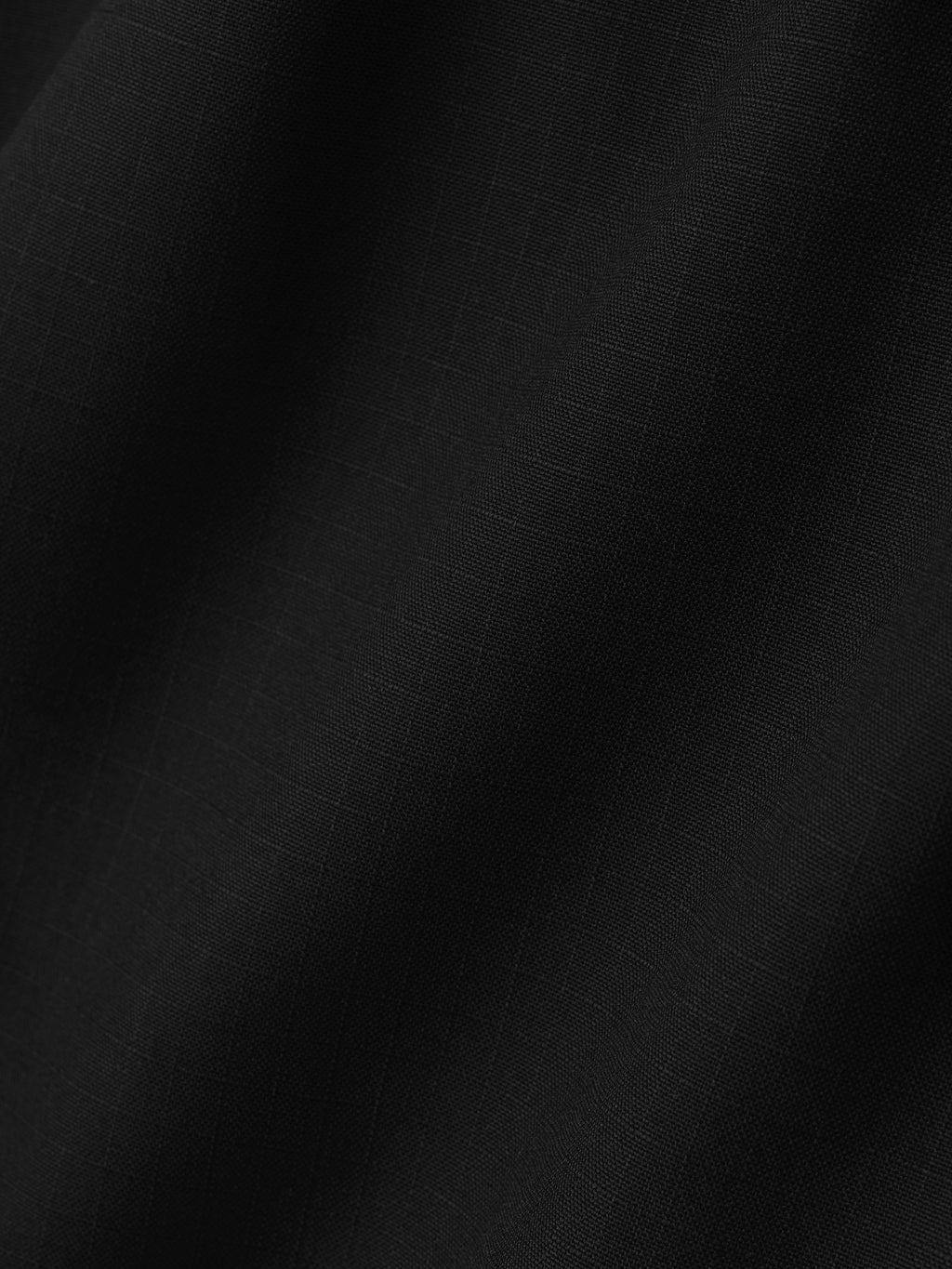 close-up of black rip-stop virgin wool fabric with subtle grid pattern and smooth matte texture