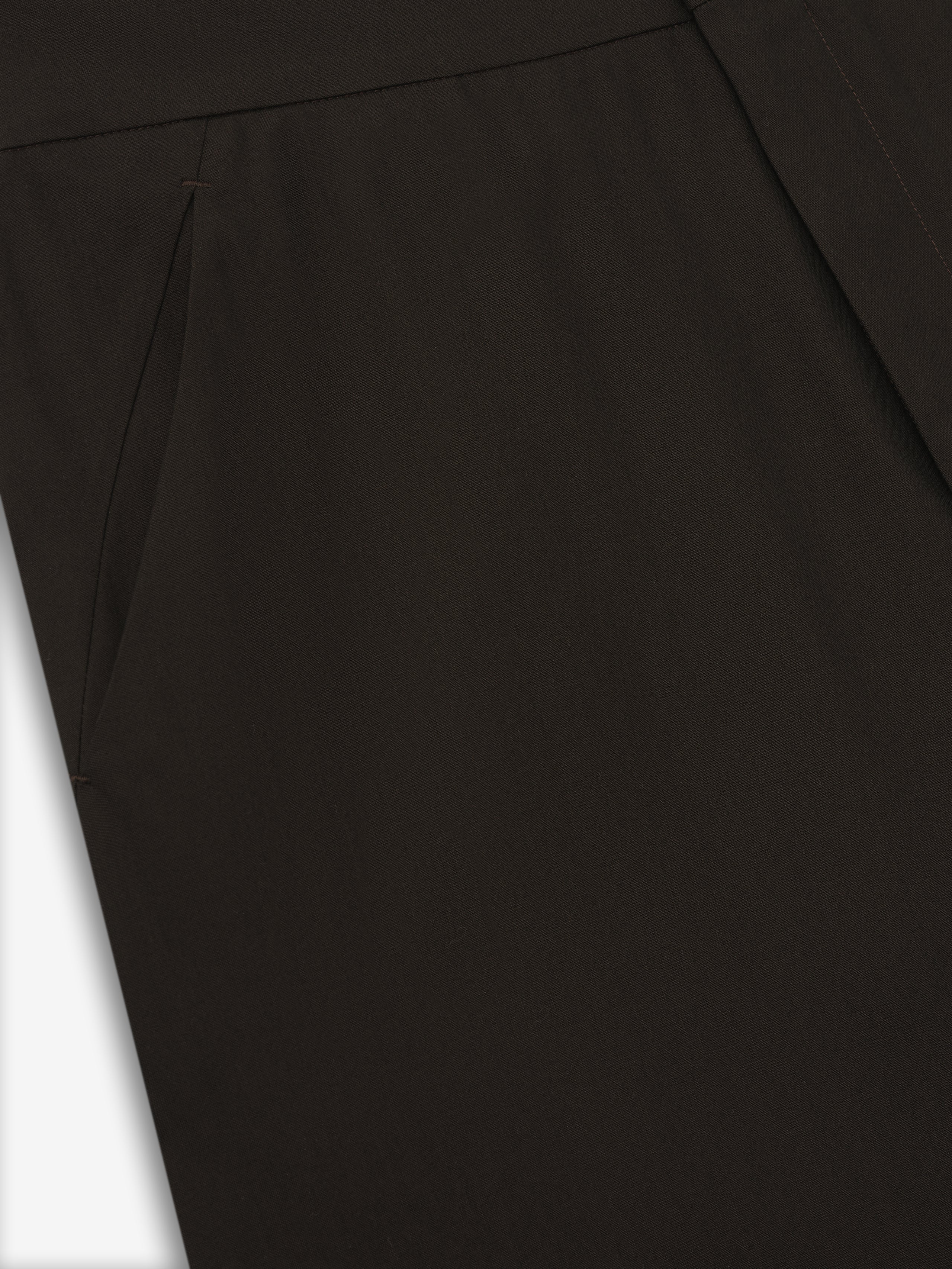 close-up of dark brown womens worker pants showcasing smooth fabric and side slit pocket detail on neutral background