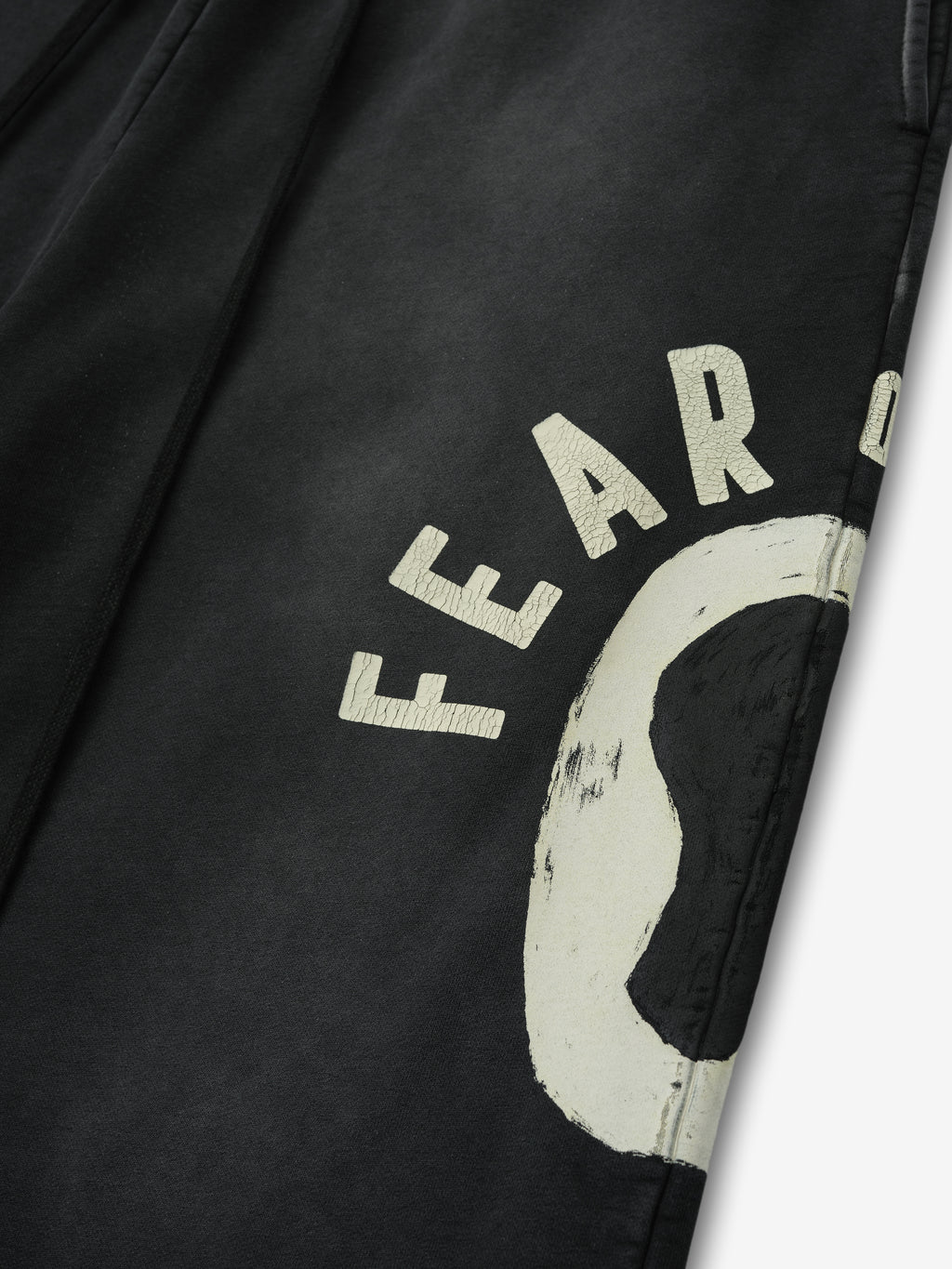 Detailed close-up of black DSYF Wide Leg Sweatpant showing off-white distressed "FEAR" text and graphic near thigh area in first gallery image