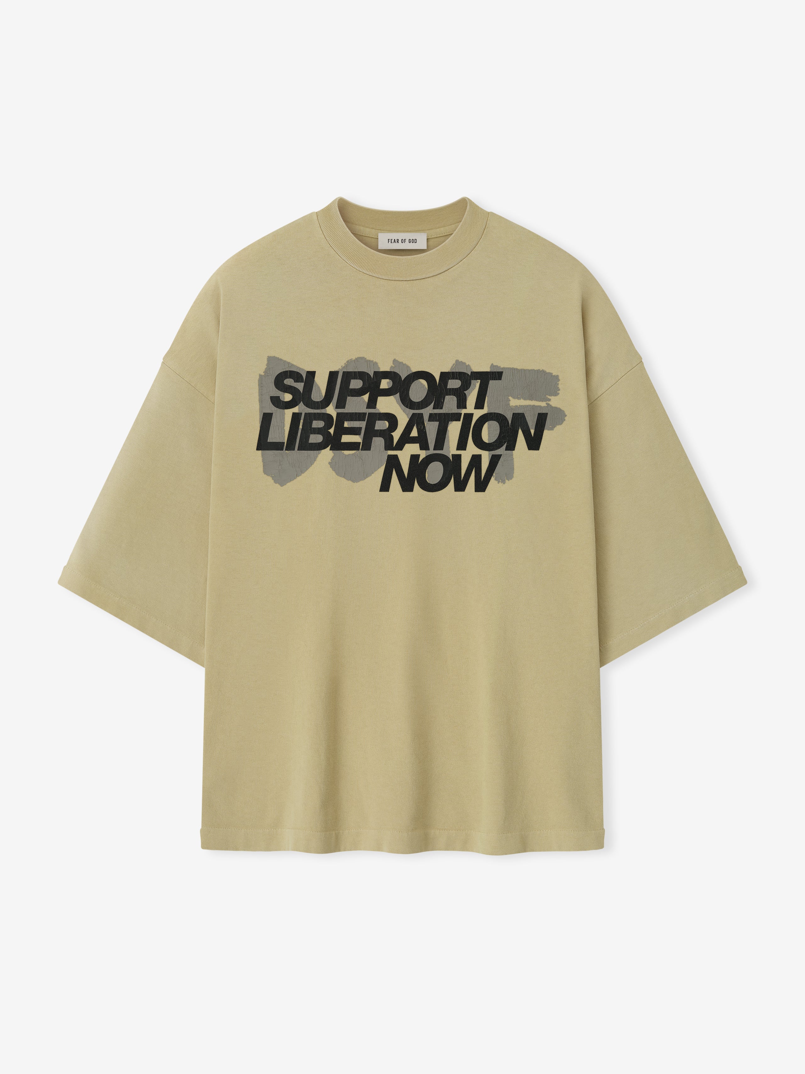Front view of clay Liberation Now Tee with bold black "Support Liberation Now" text over gray brushstroke background centered on fabric
