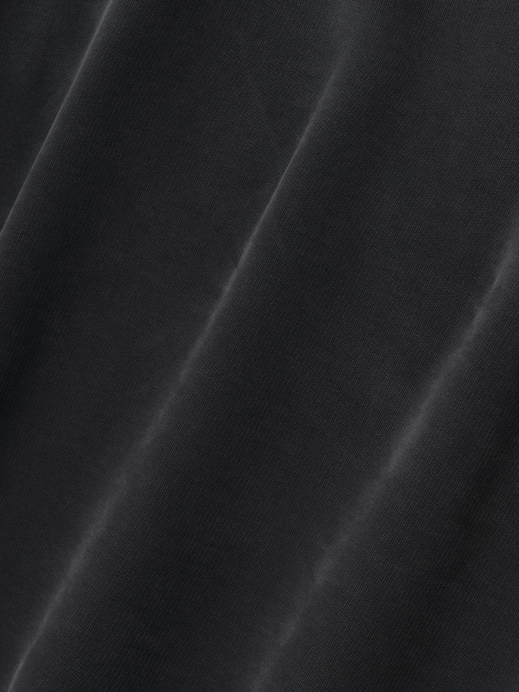 close-up of black cotton fleece fabric with subtle sun-faded finish and soft texture on Fear of God hoodie