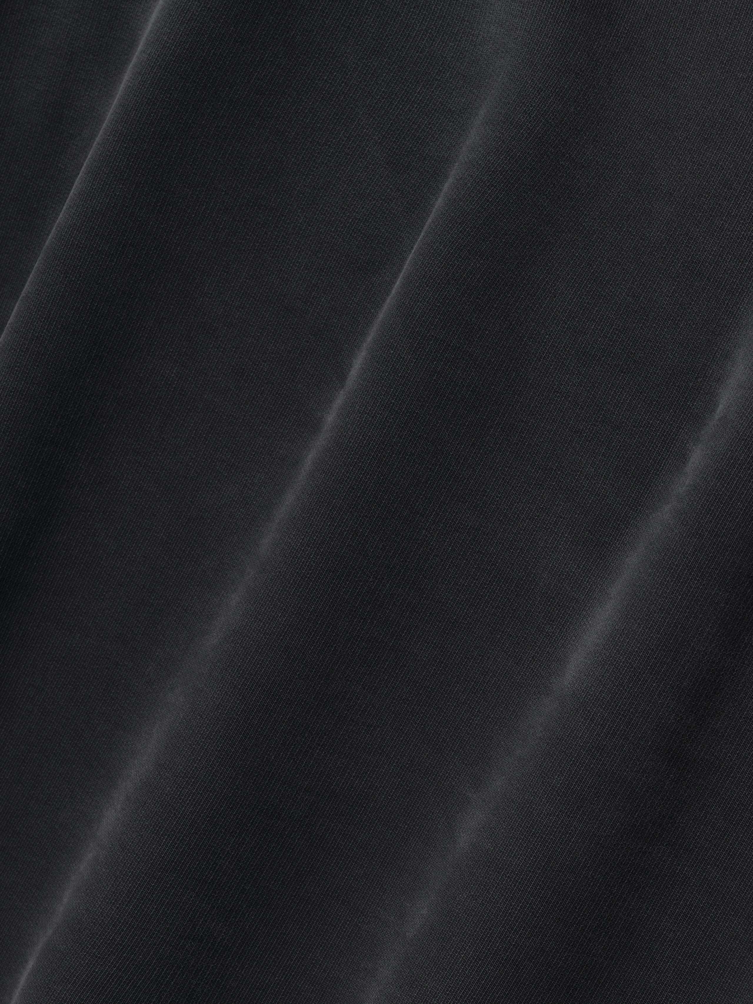 close-up of black cotton fleece fabric with subtle sun-faded finish and soft texture on Fear of God hoodie
