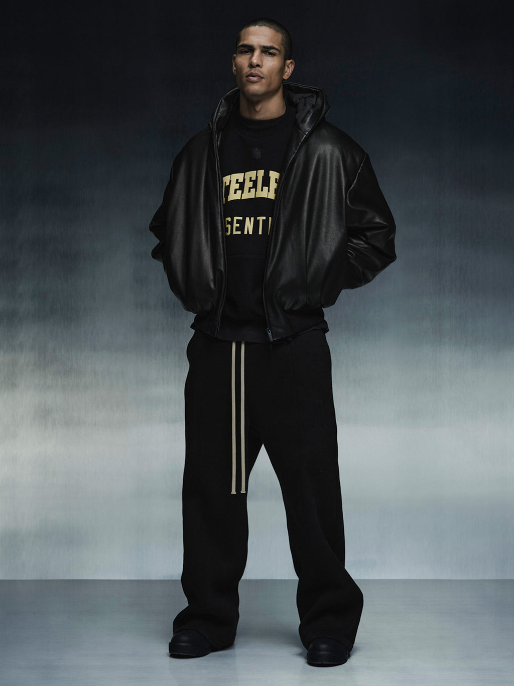 Full body view of model wearing Steelers Sport Crewneck with gold lettering under black leather jacket, gallery 0 IMAGE27v2.jpg