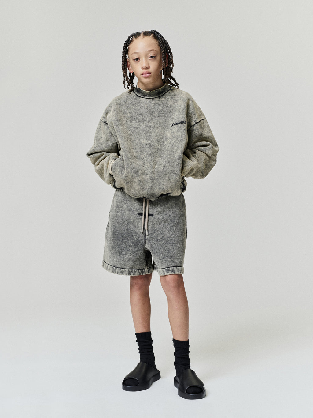 Kids Classic Raglan Hi-Crewneck in gray worn by a child with matching shorts black socks and sandals in a studio Tops outfit